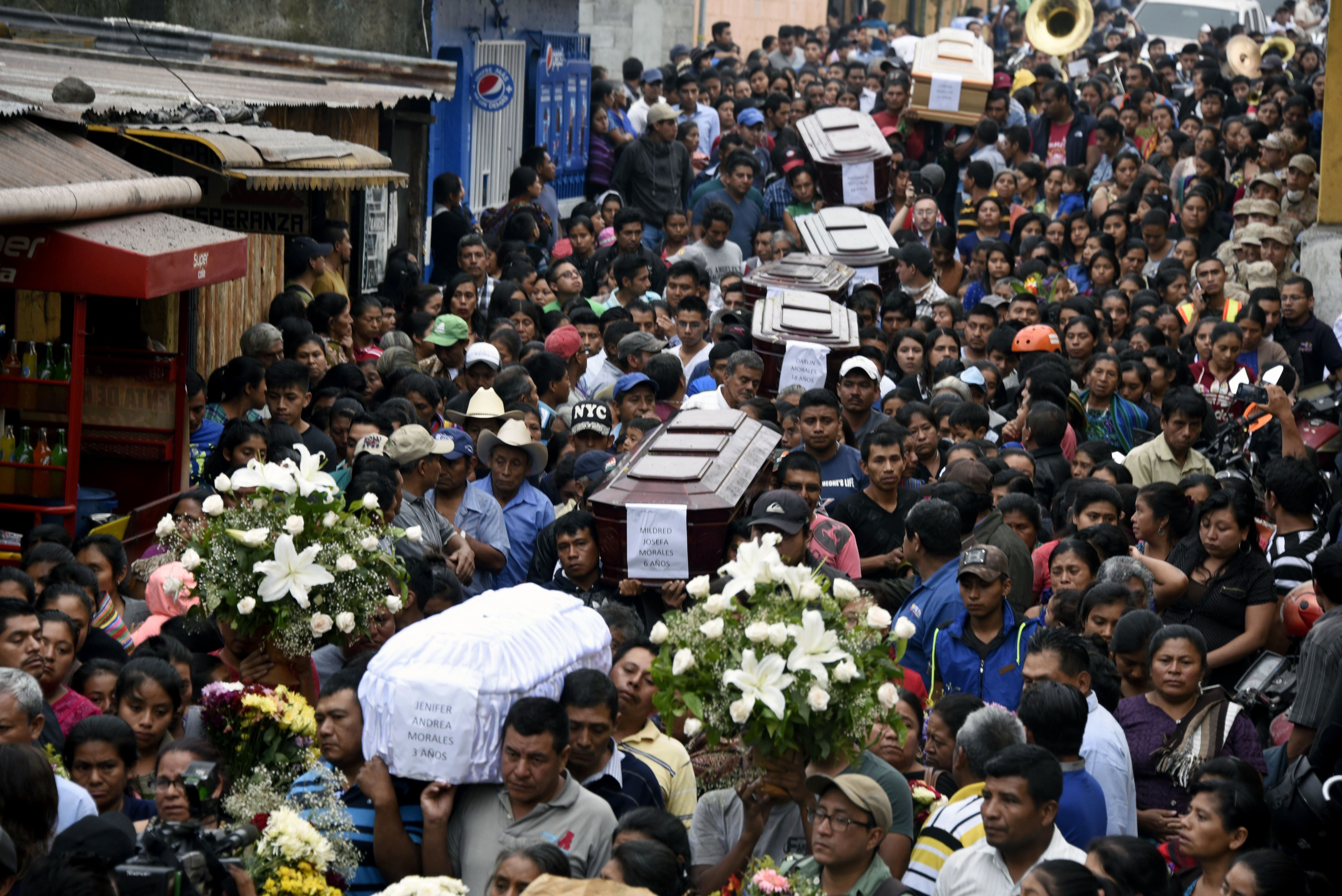 Residents carry the coffins of seven people who died following the eruption of the Fuego volcano.