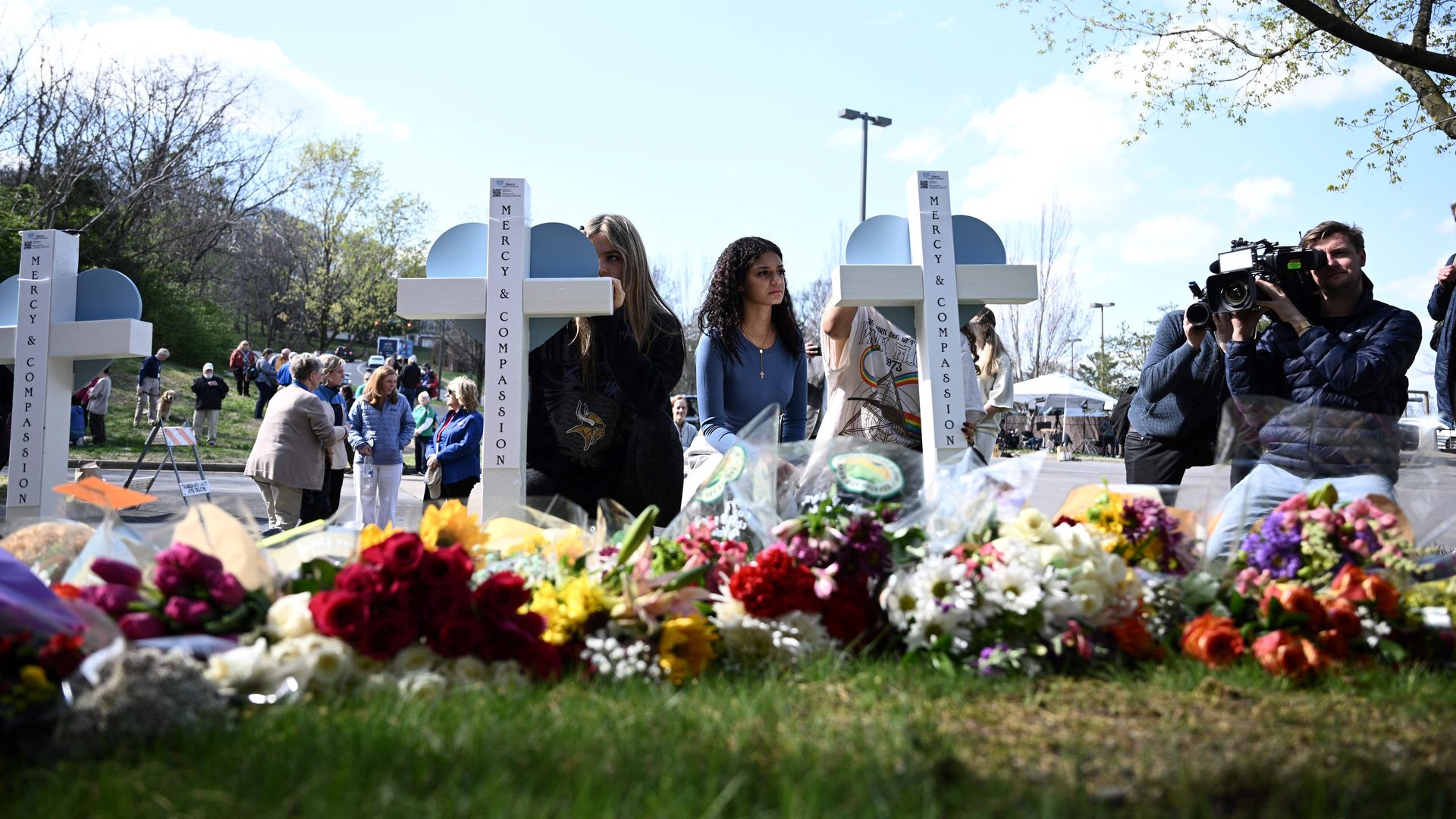 People pay their respects at a makeshift memorial for victims at the Covenant School