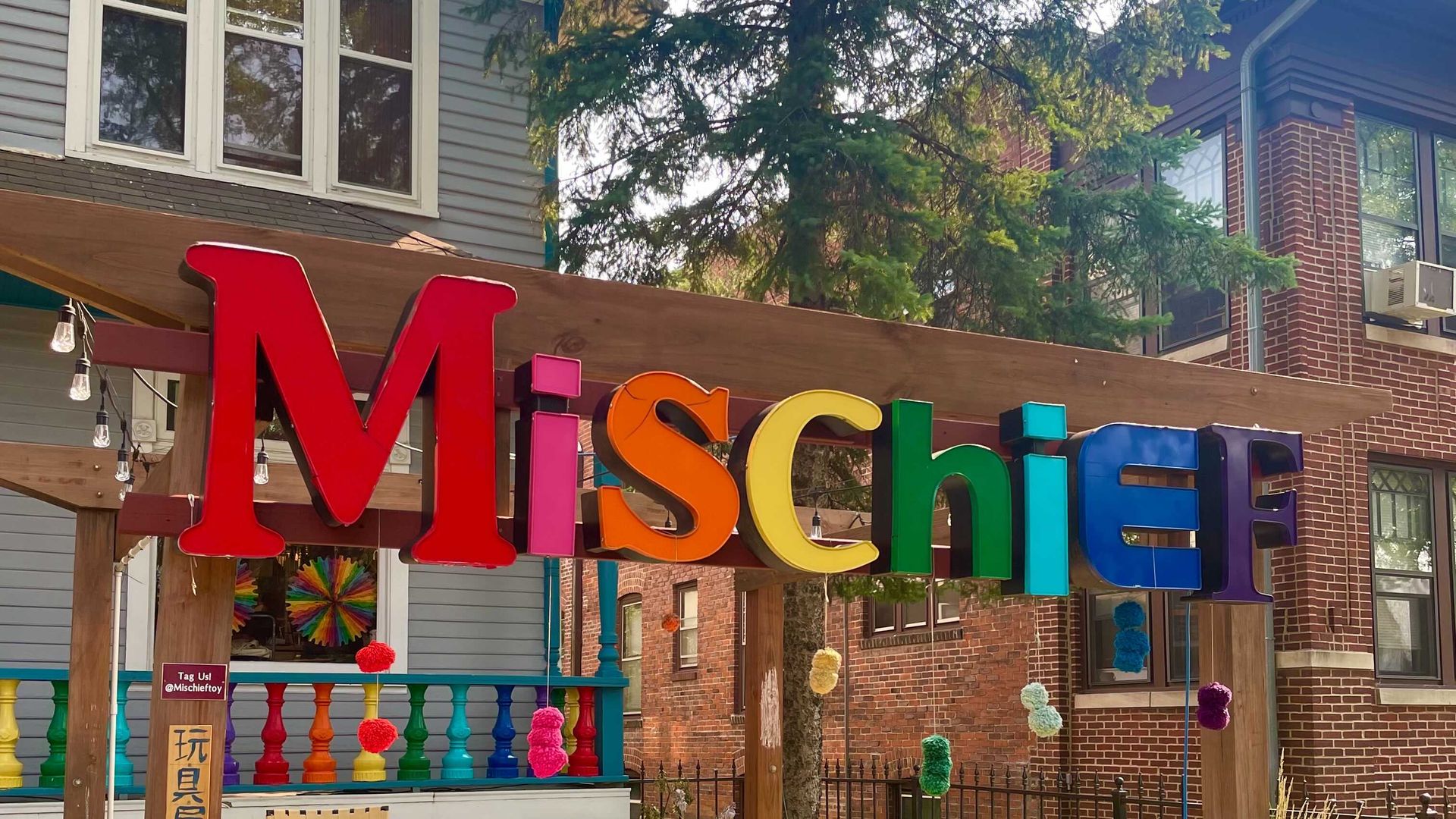 rainbow letters in front of a house spelling the word mischief