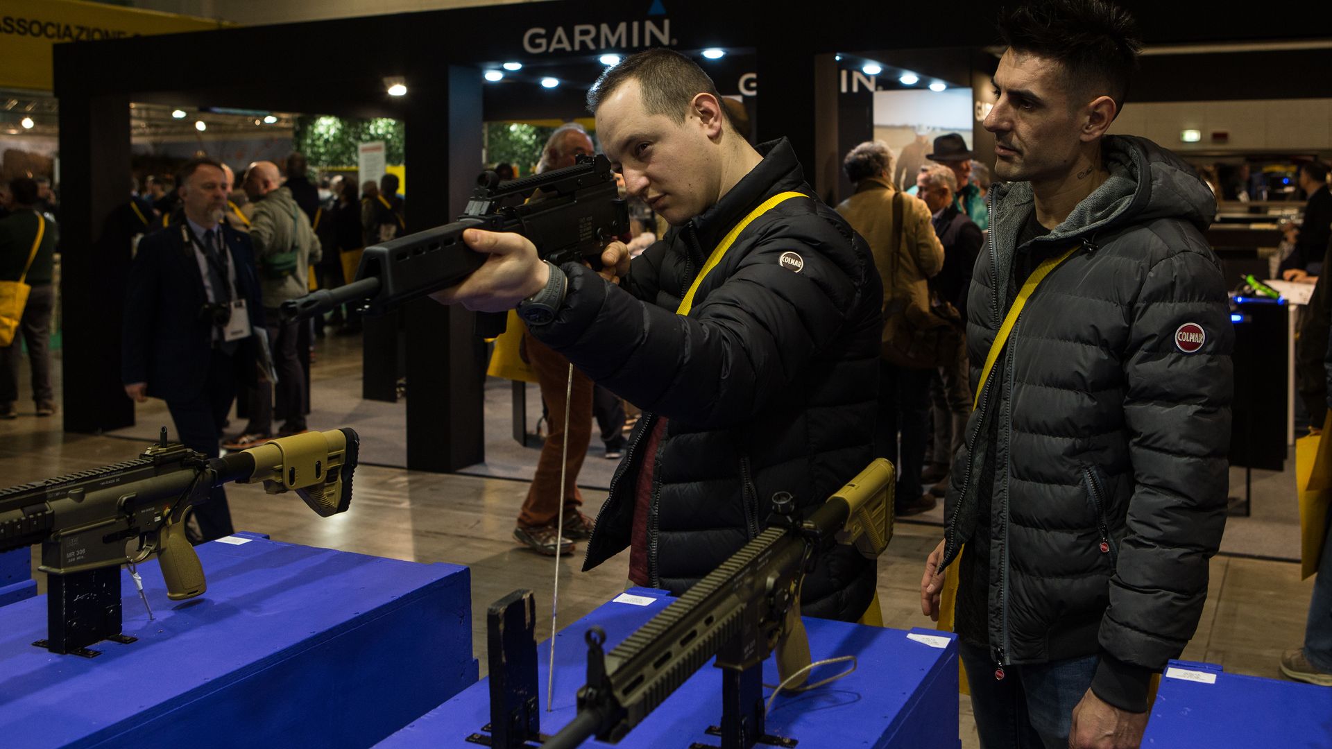 two men trying out a gun at a gun show