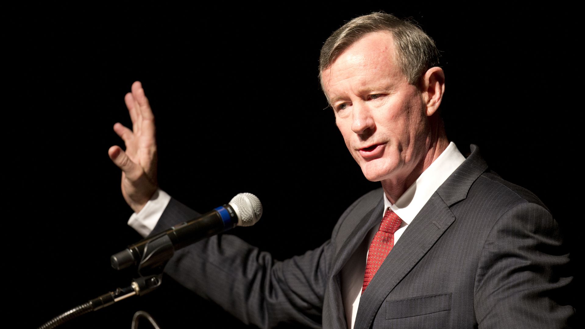 McRaven speaks at podium waving one hand.