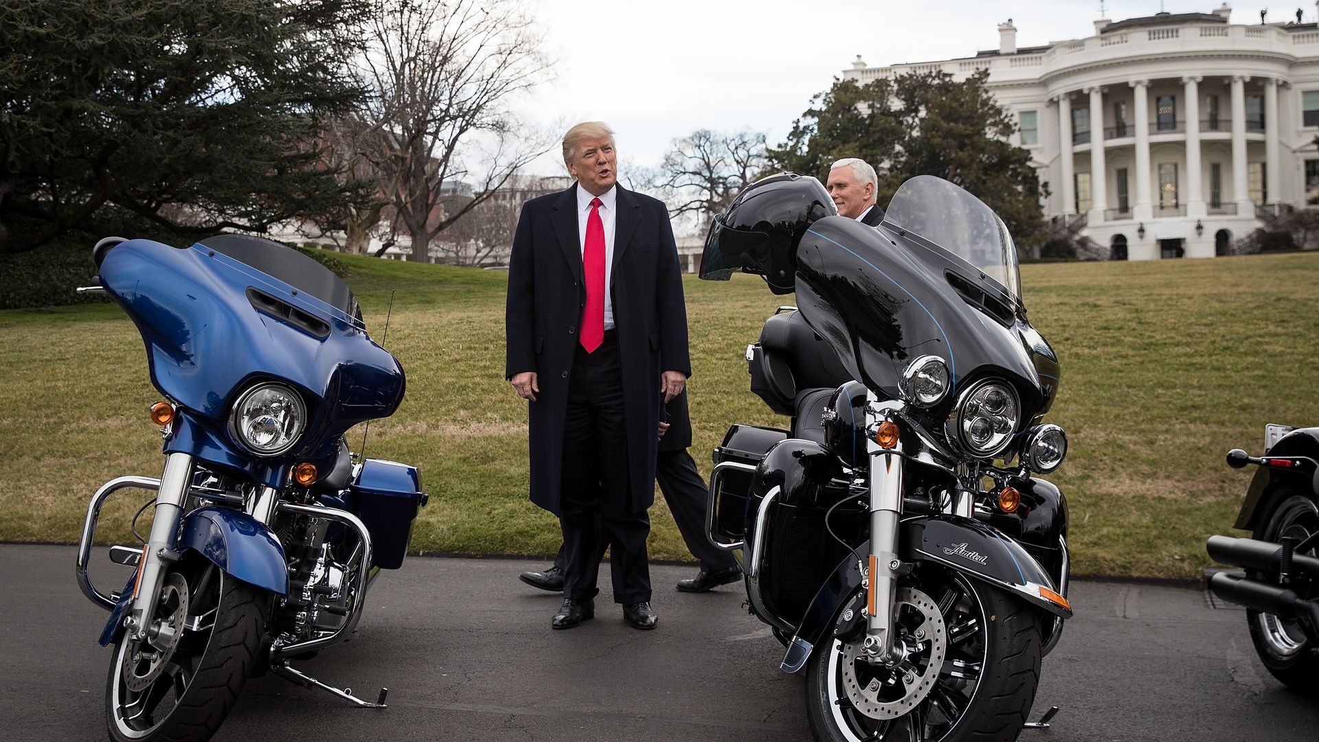 In this image, President Trump stands between two motorcycles on the White House lawn. 