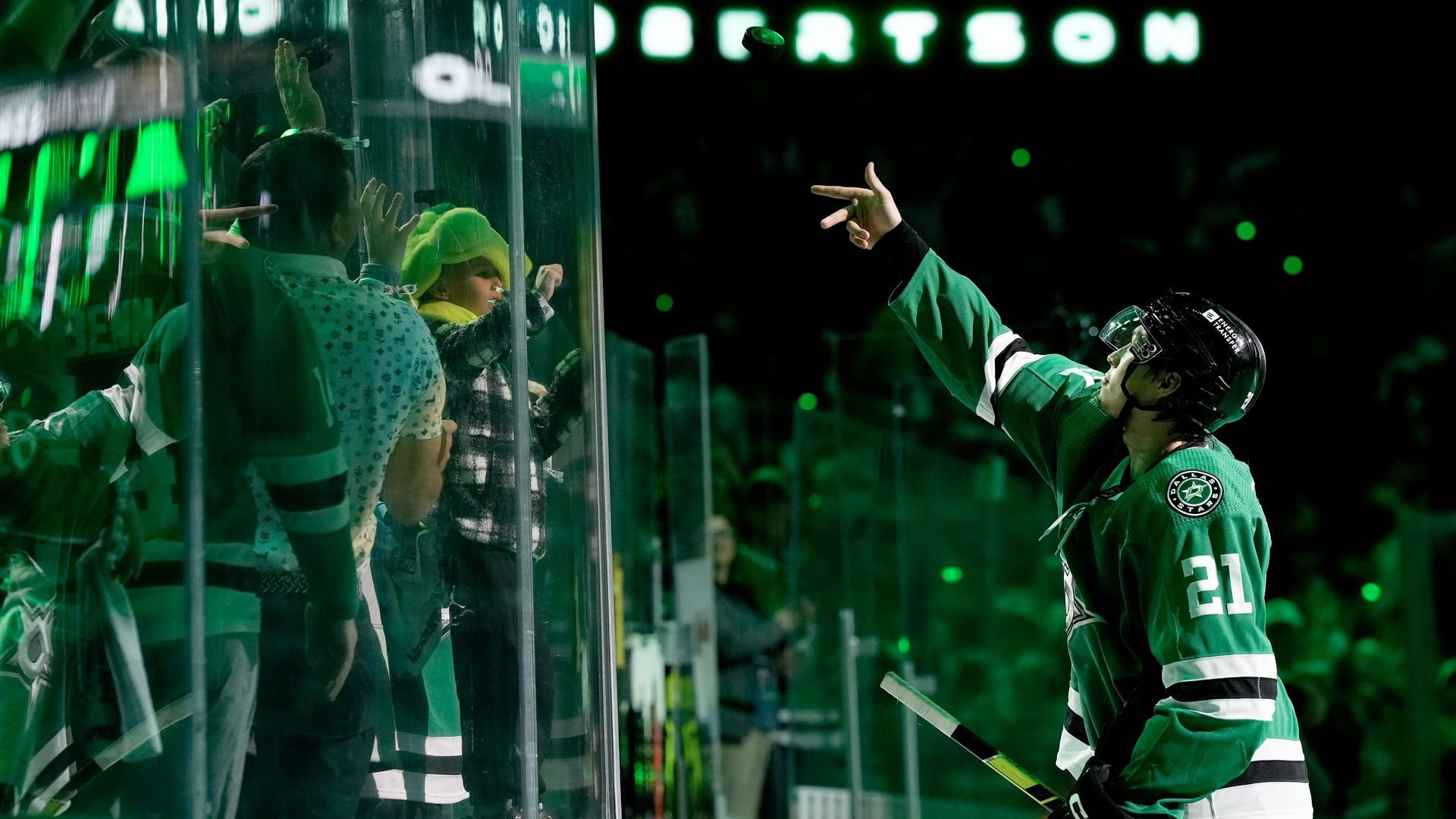 Dallas Stars Jason Robertson tosses a puck to fans