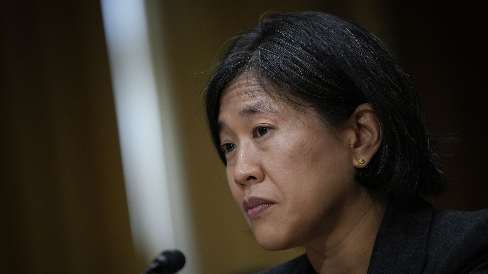 Photo of Katherine Tai in front of a mic