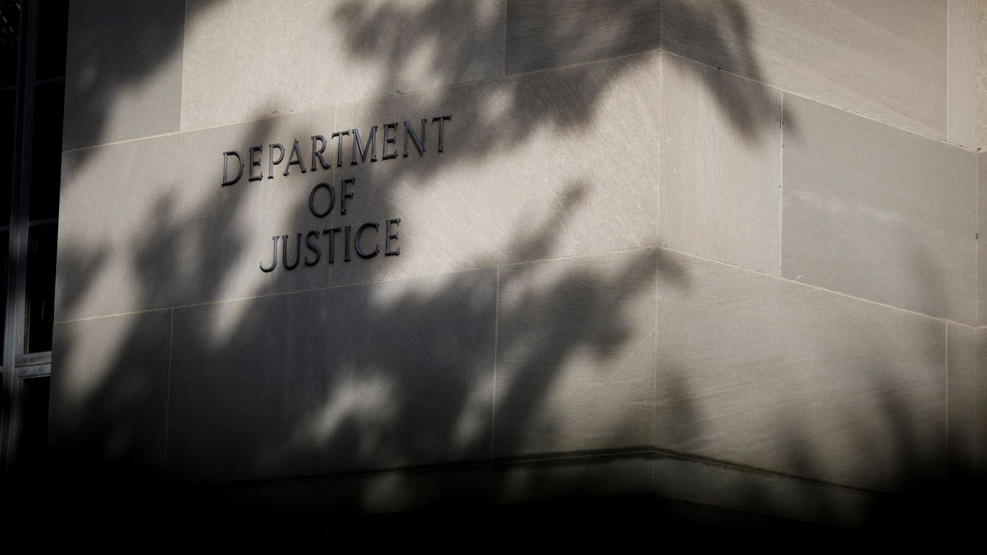 A sign for the Department of Justice on the side of a building 