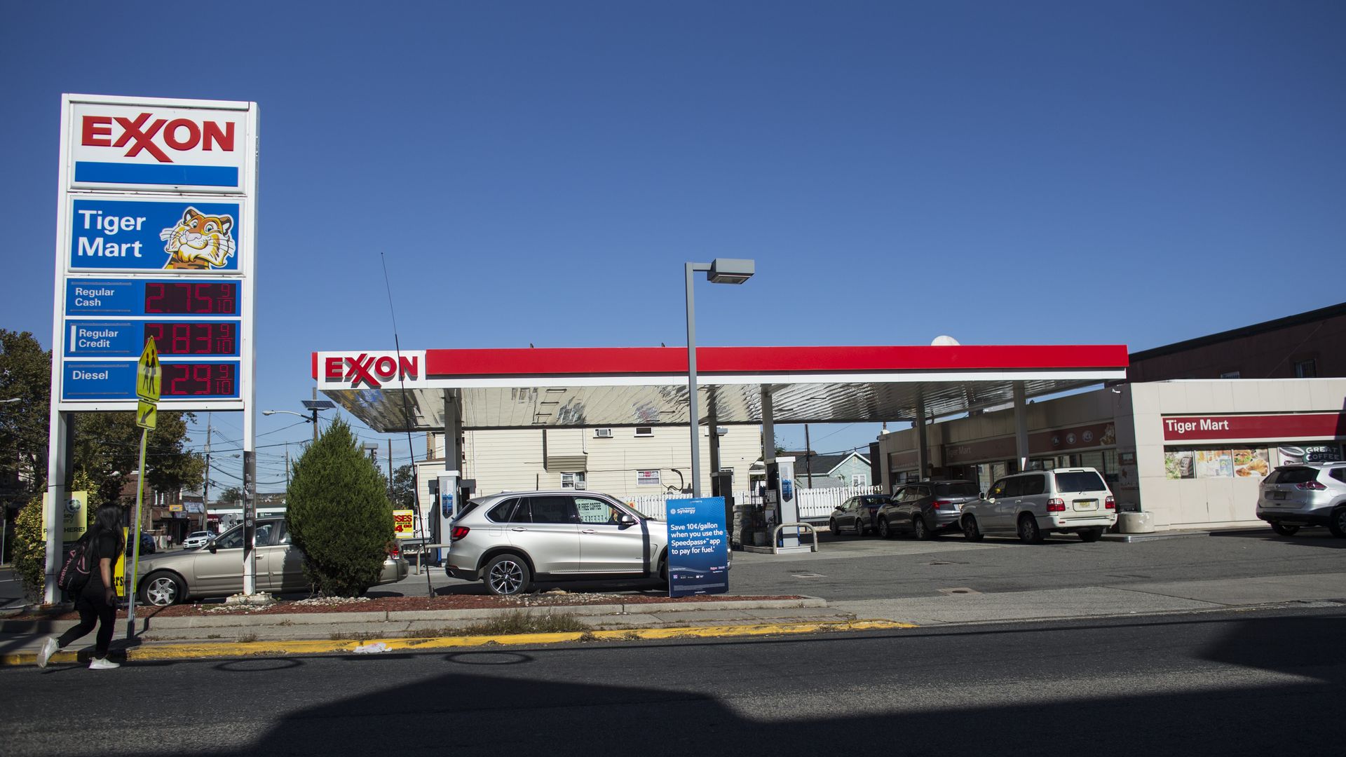In this image, an ExxonMobil gas station is pictured behind an empty street. 