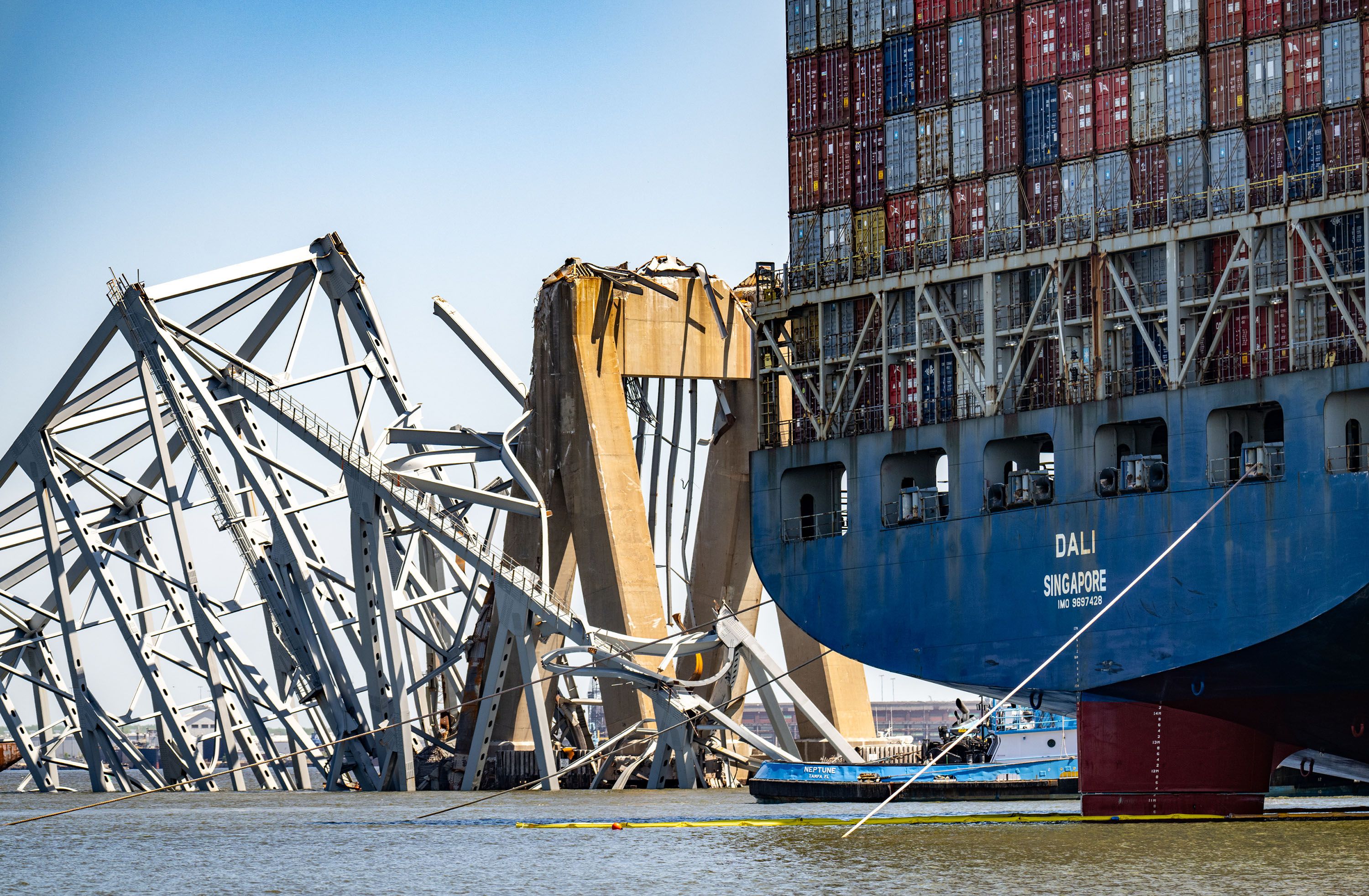 The wreckage of the Francis Scott Key Bridge is seen beyond the stern of the container ship Dali three weeks after the catastrophic collapse