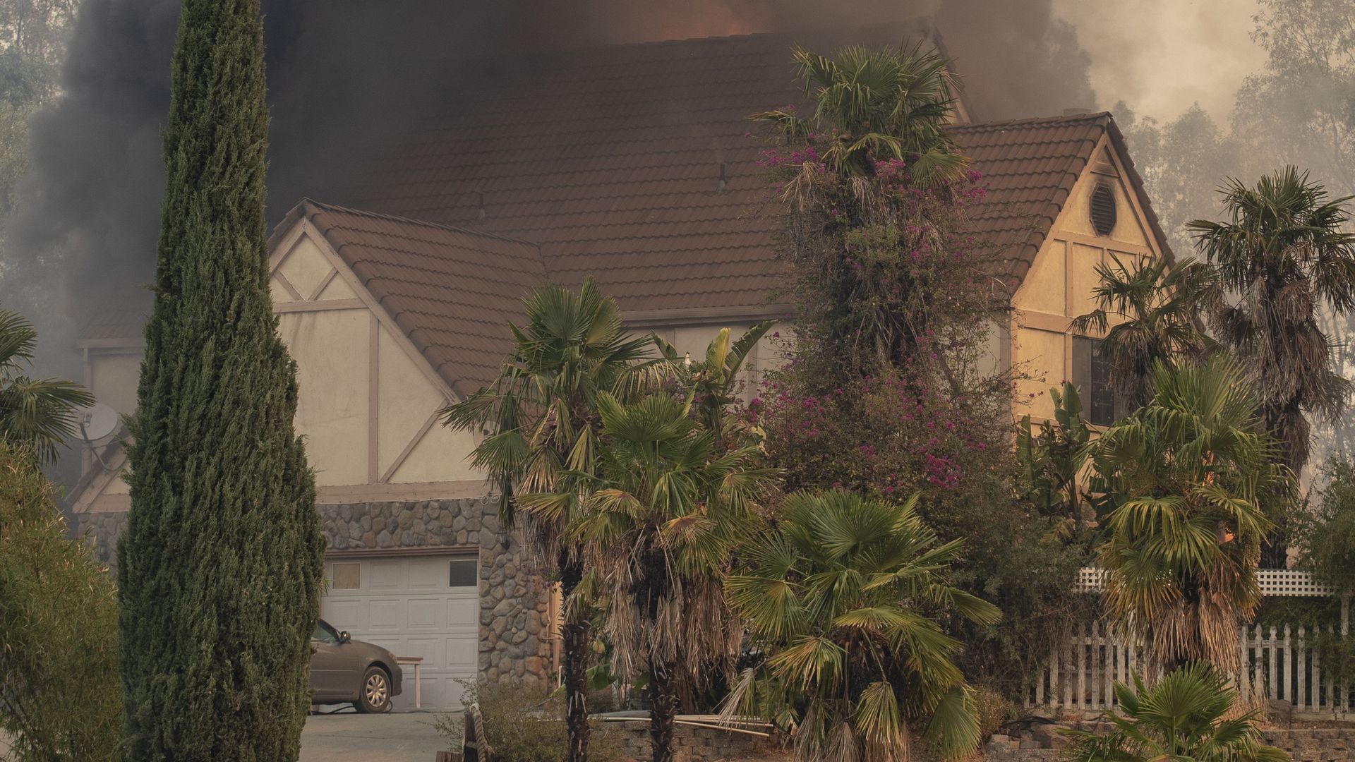A man trying to save a home in Vacaville, Calif., is consoled by a firefighter Wednesday.