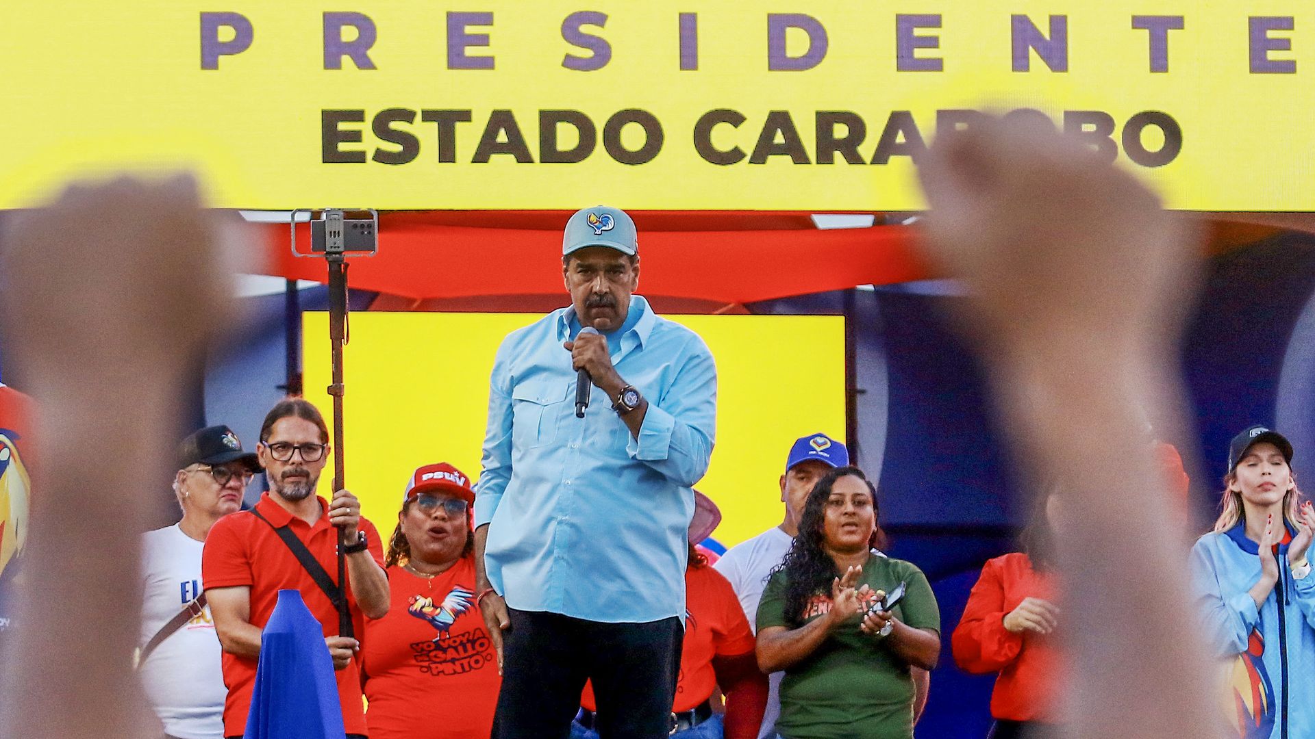 Venezuela president Nicolas Maduro speaks at a rally, holding a microphone