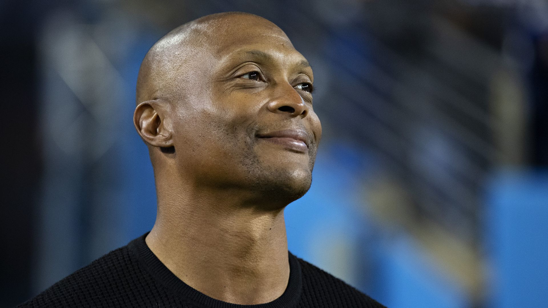 Photo of TSU football coach Eddie George looking to the side and smiling.