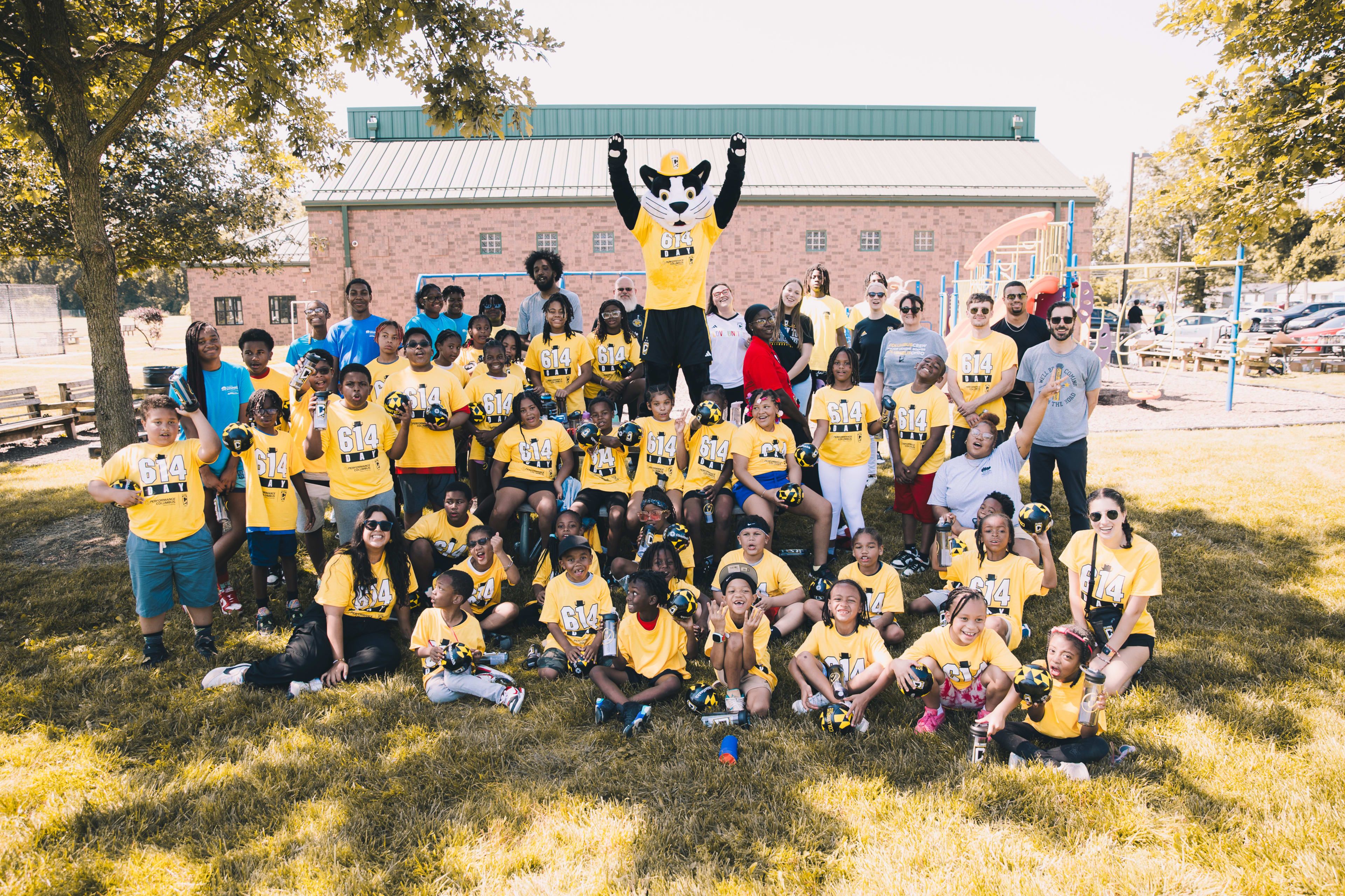 School children pose with Columbus Crew mascot Crew Cat
