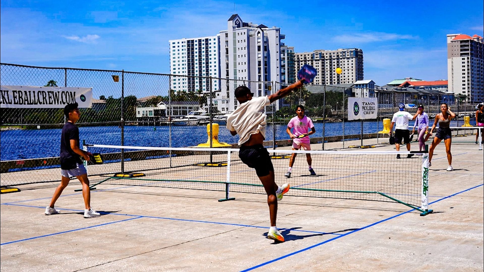 A player slams a shot down in a waterfront pickleball game