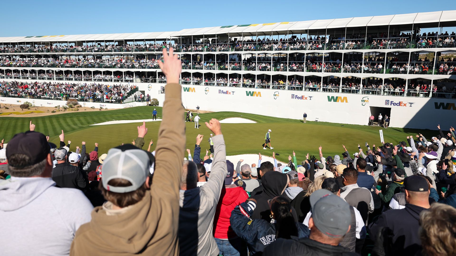 Fans cheer at a golf event. 