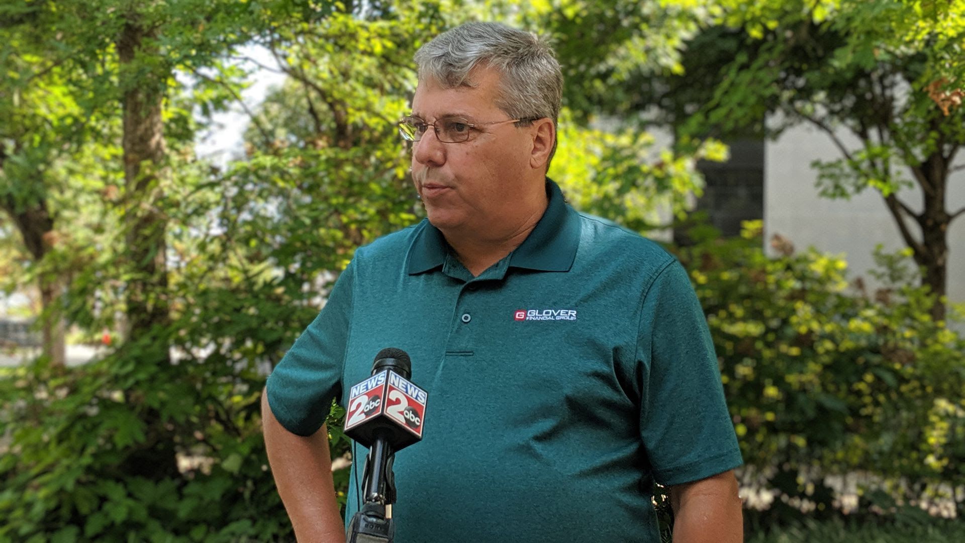 Steve Glover standing in front of a mic in a green polo shirt