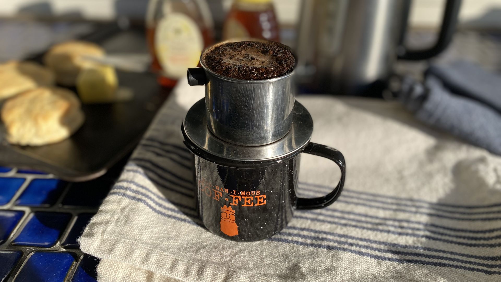 A single cup coffee maker atop a mug.