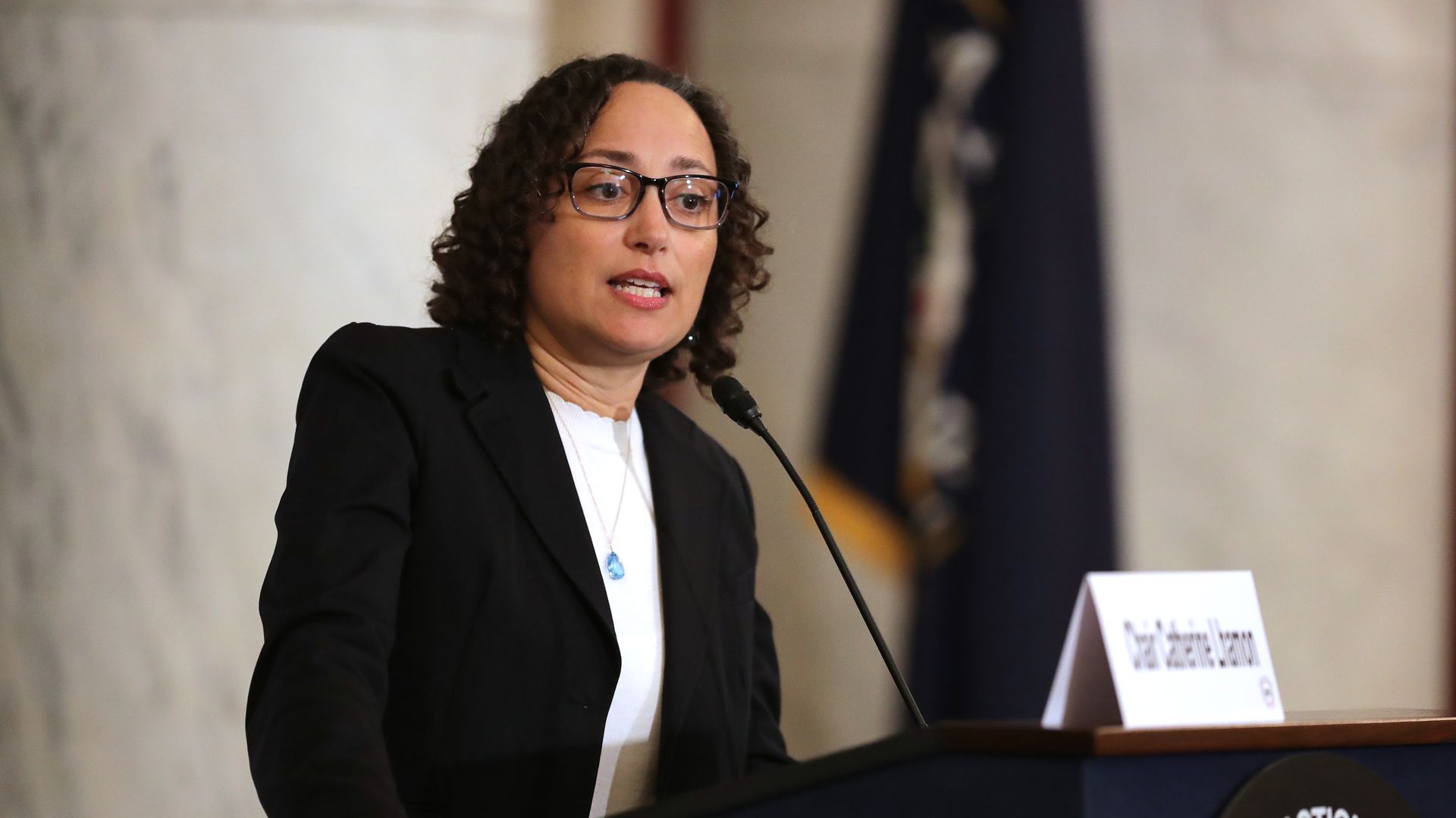 Photo of Catherine Lhamon speaking into a mic at a podium