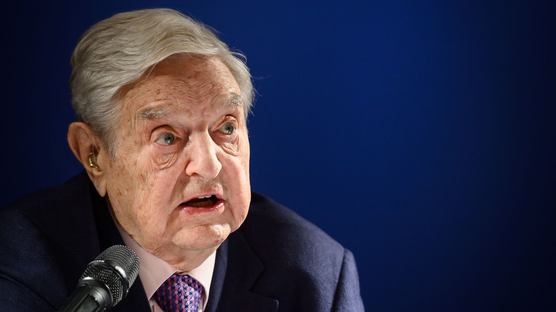 US investor and philanthropist George Soros speaks into a microphone.