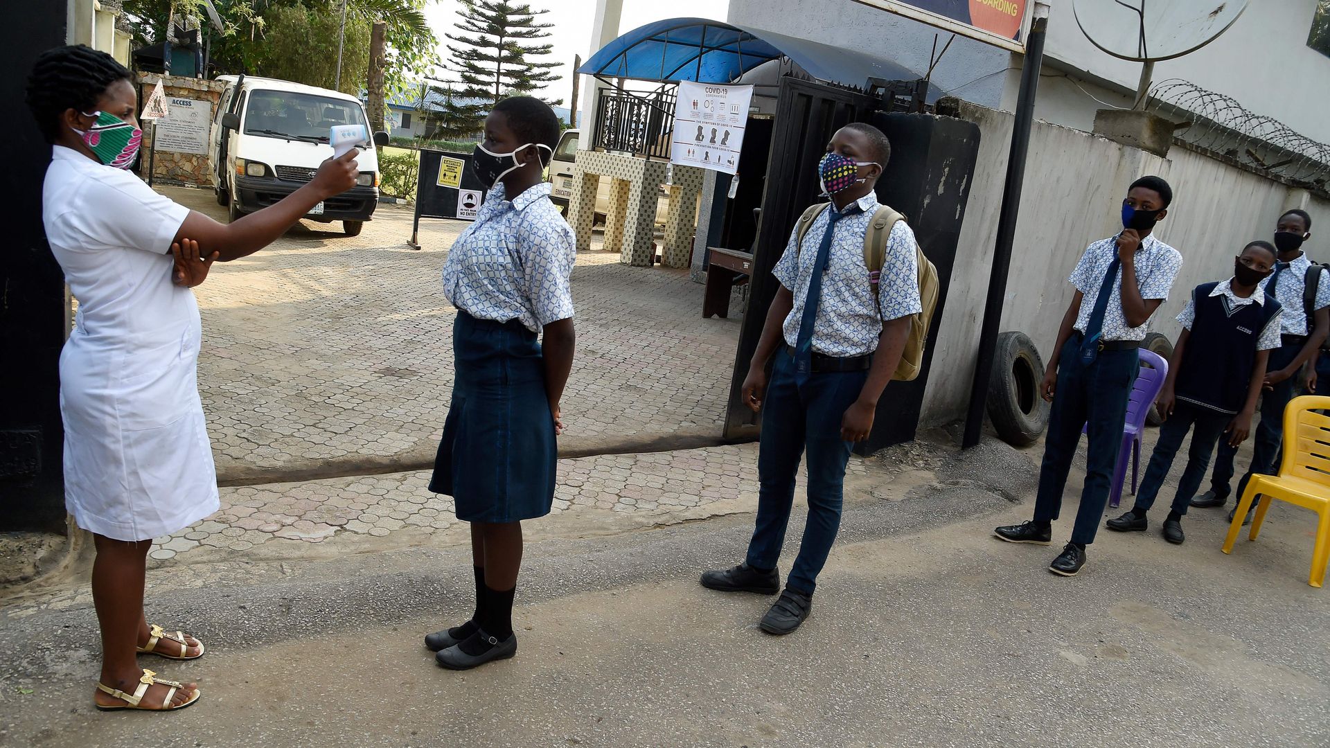 A health worker in Nigeria checks students' temperatures on August 4.
