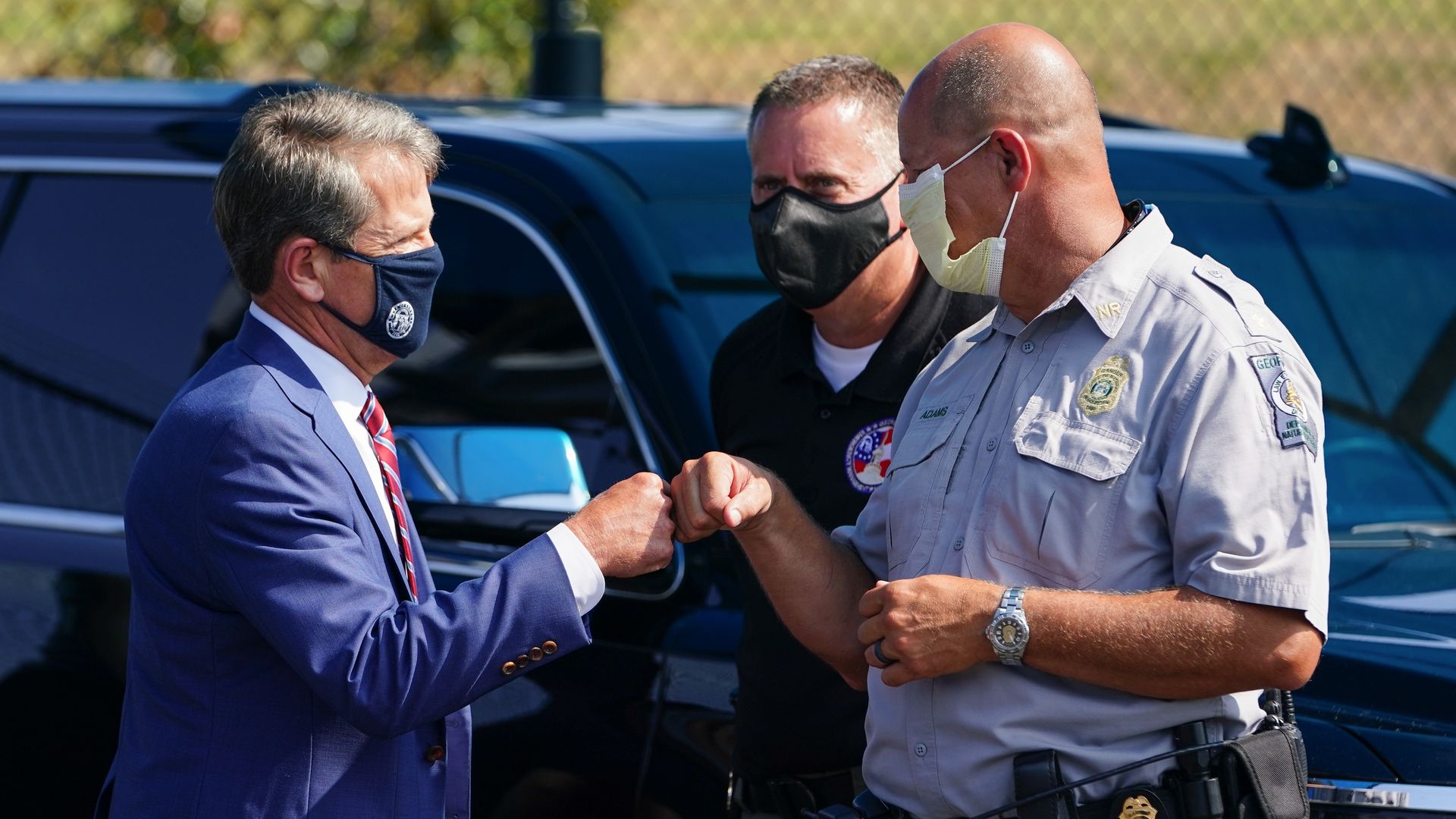 Gov. Brian Kemp of Georgia fist bumps a police officer.