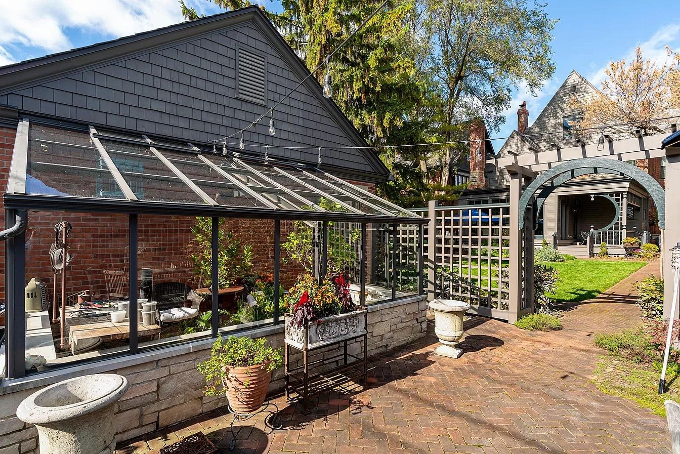 A garage and greenhouse leading to a backyard.