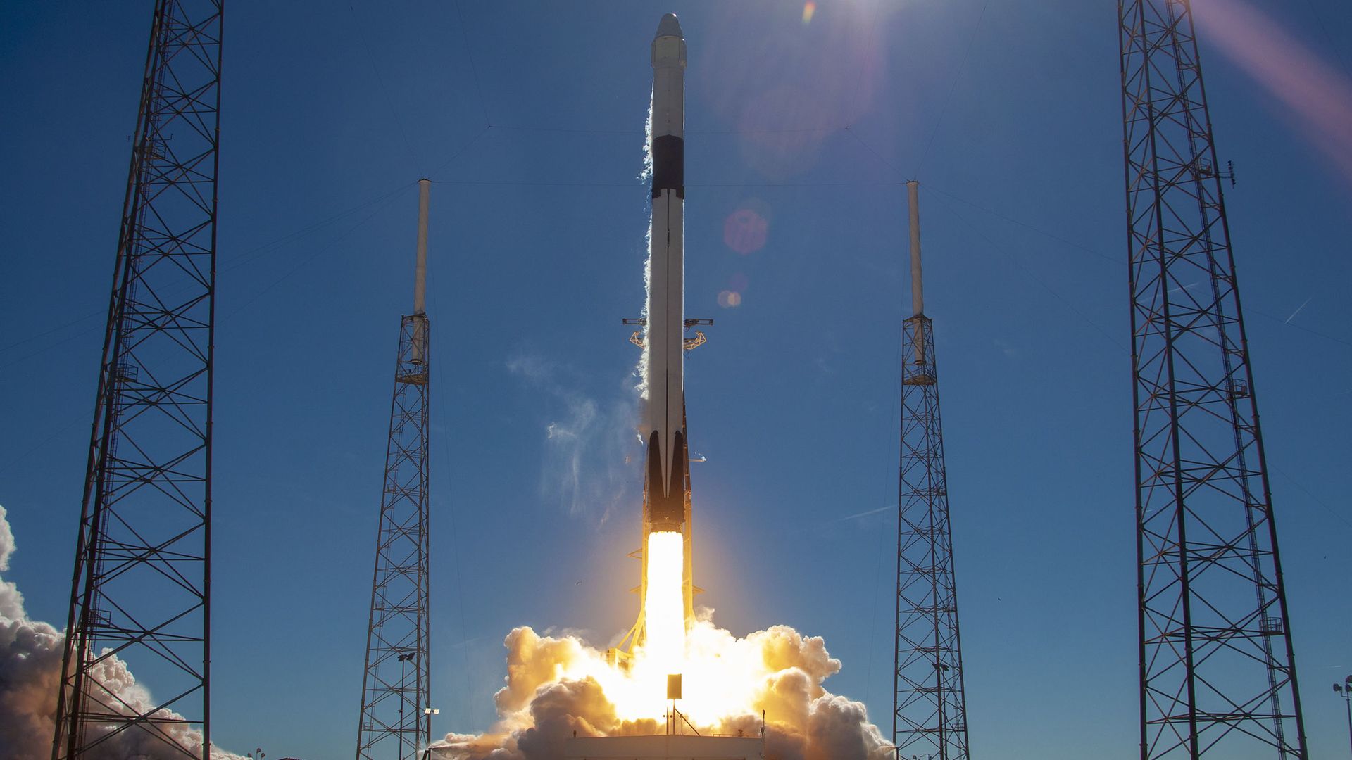 A Falcon 9 rocket launching on a blue day