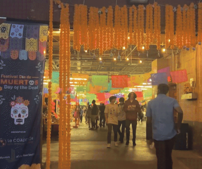 gif of the inside of a warehouse space decorated with colorful banners for day of the dead