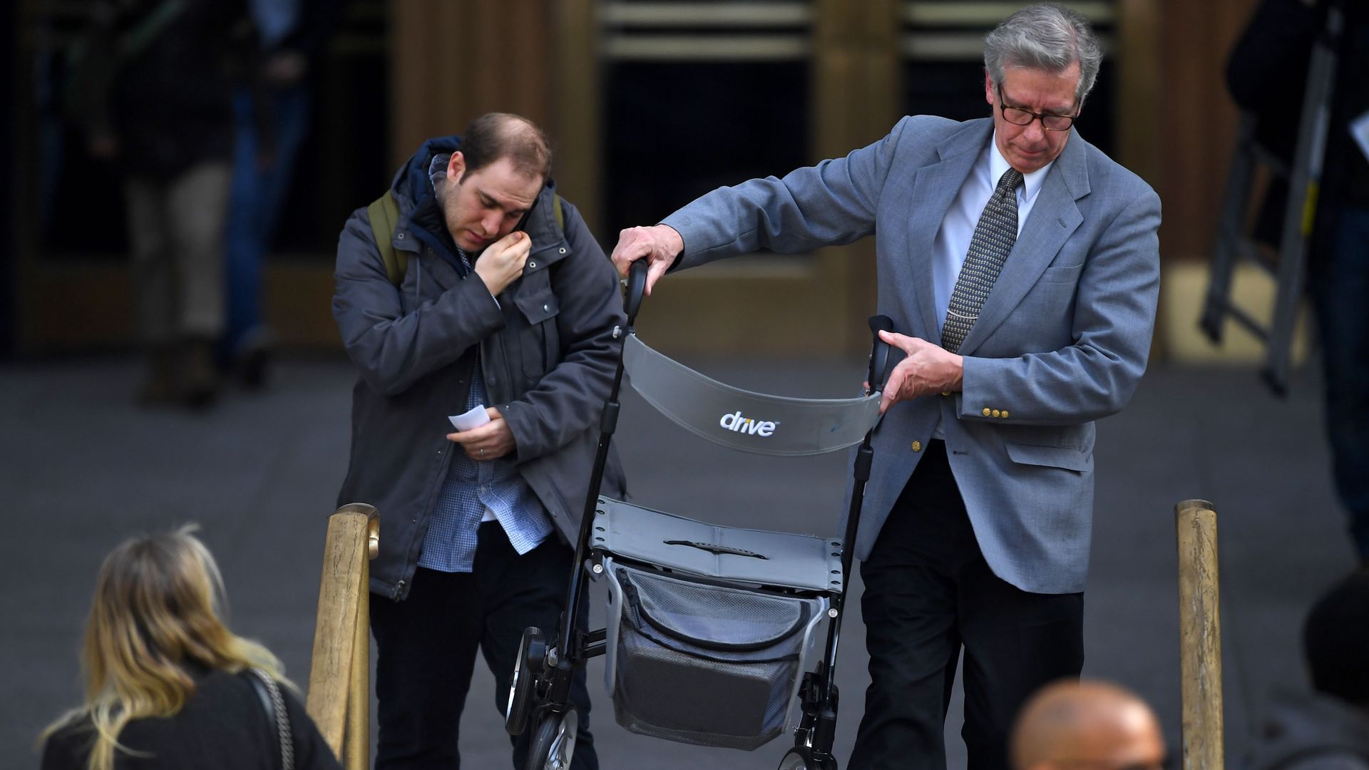 A man carries out Harvey Weinstein's walker