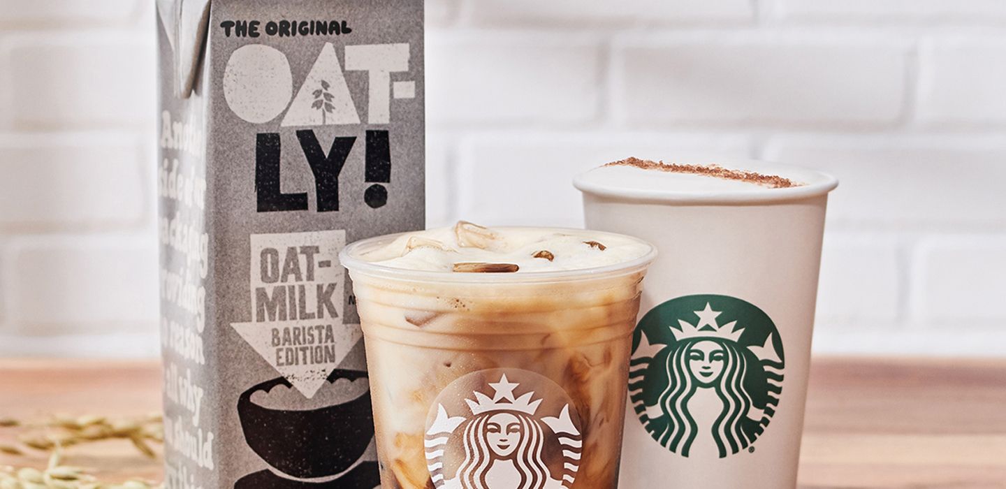 Image of "Oatly" oat milk box, alongside iced and hot Starbucks coffees
