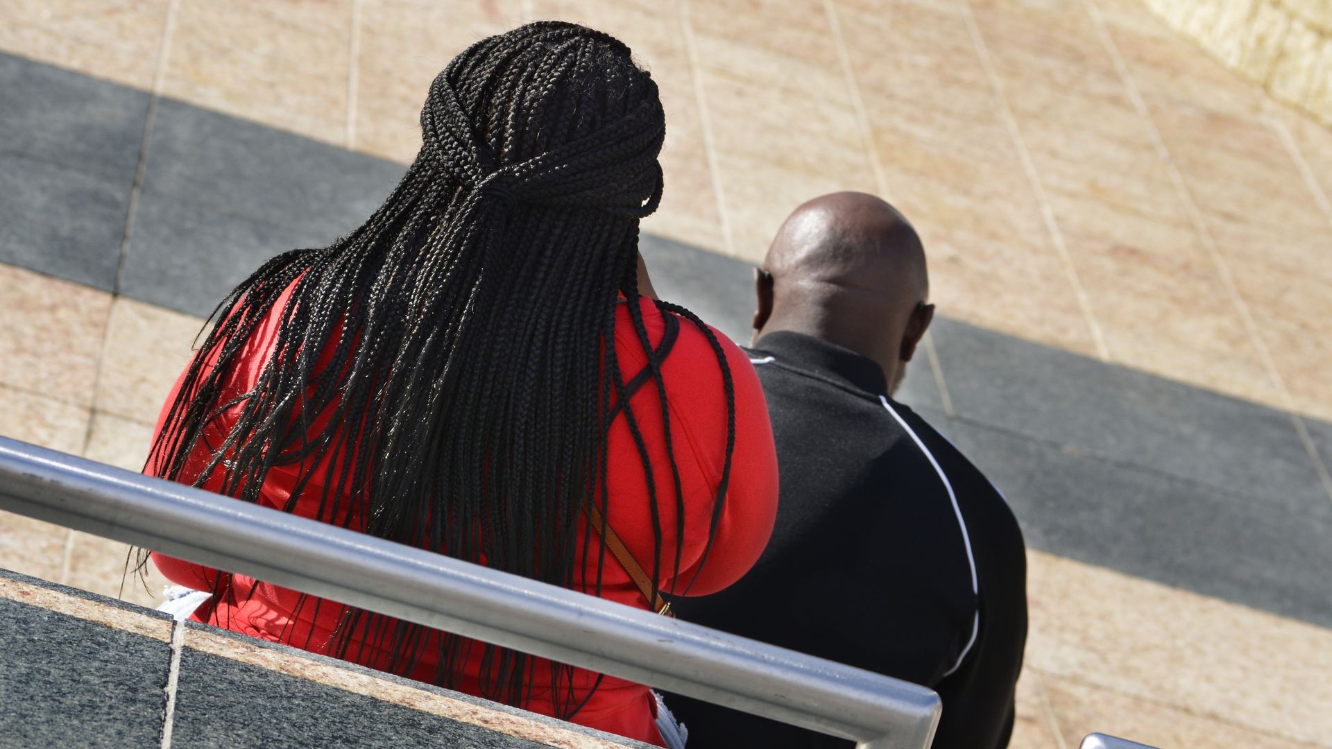 An African-American woman sits on a bench.