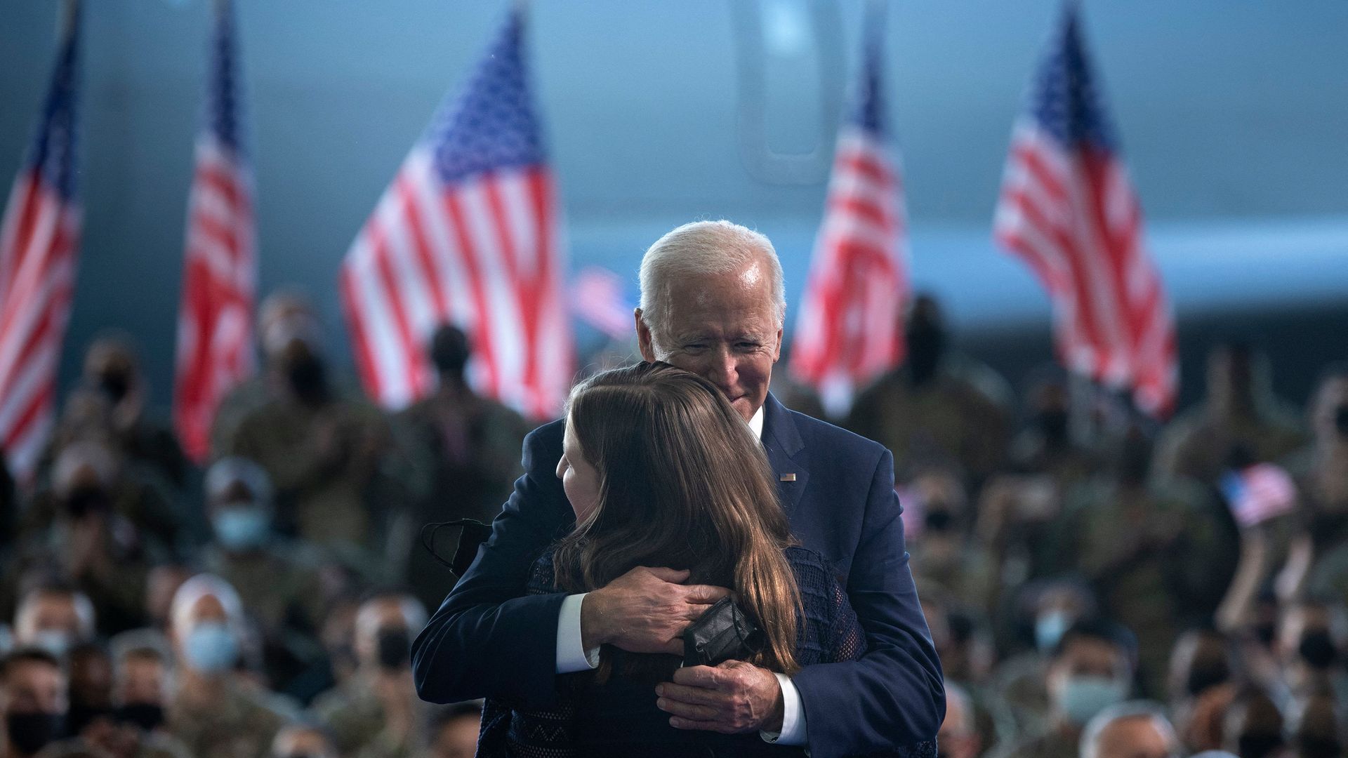 President Biden is seen embracing the 14-year-old who introduced him before he addressed U.S. troops in the U.K.