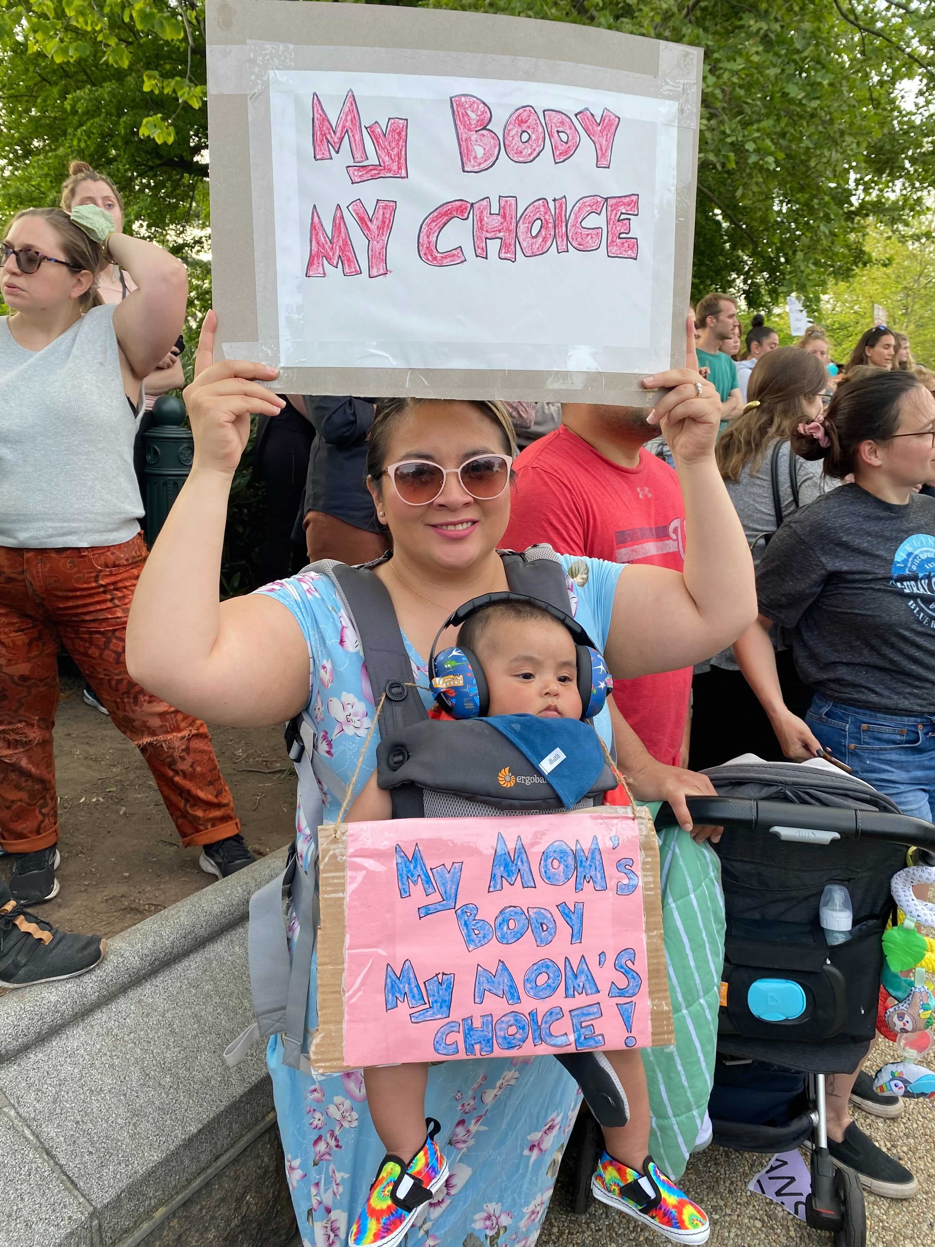 A mom and baby with signs at a pro-abortion protest at the Supreme Court.