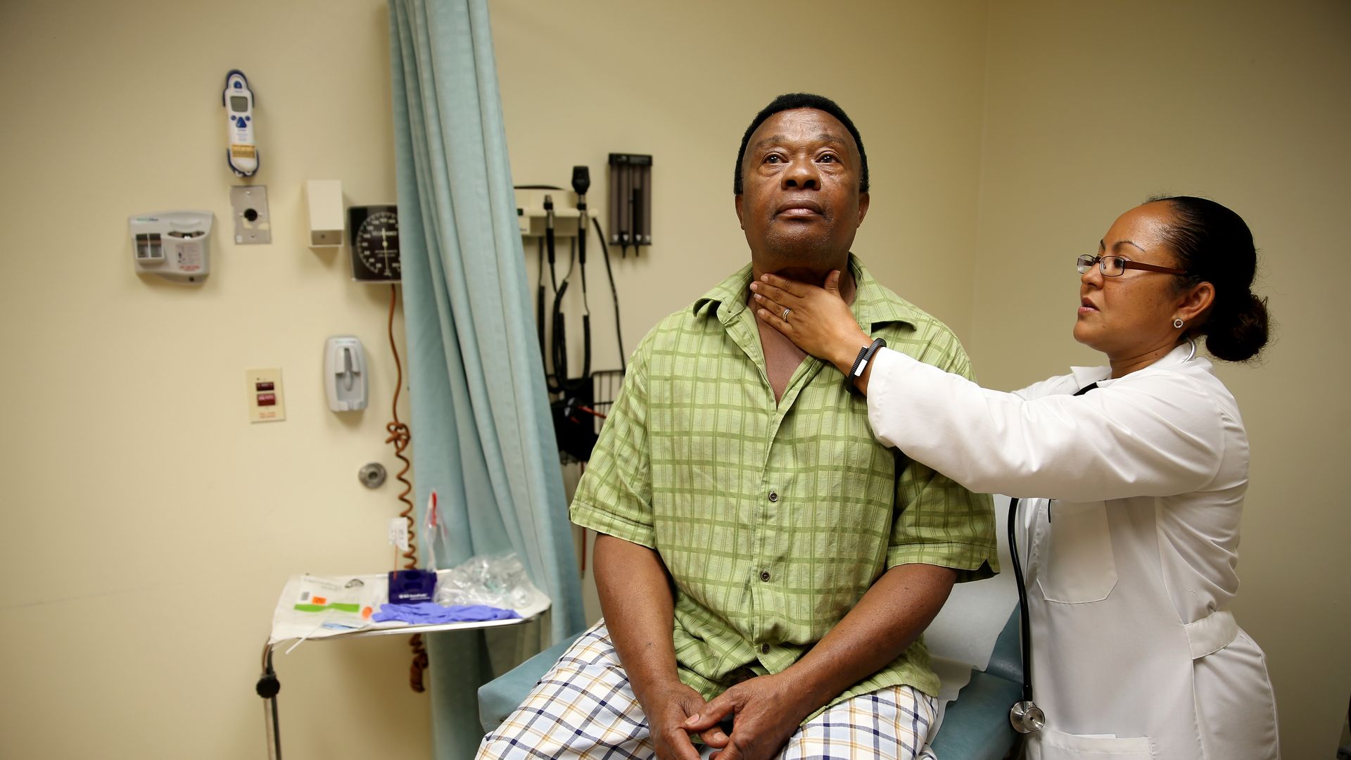 A patient receives a checkup from a doctor.
