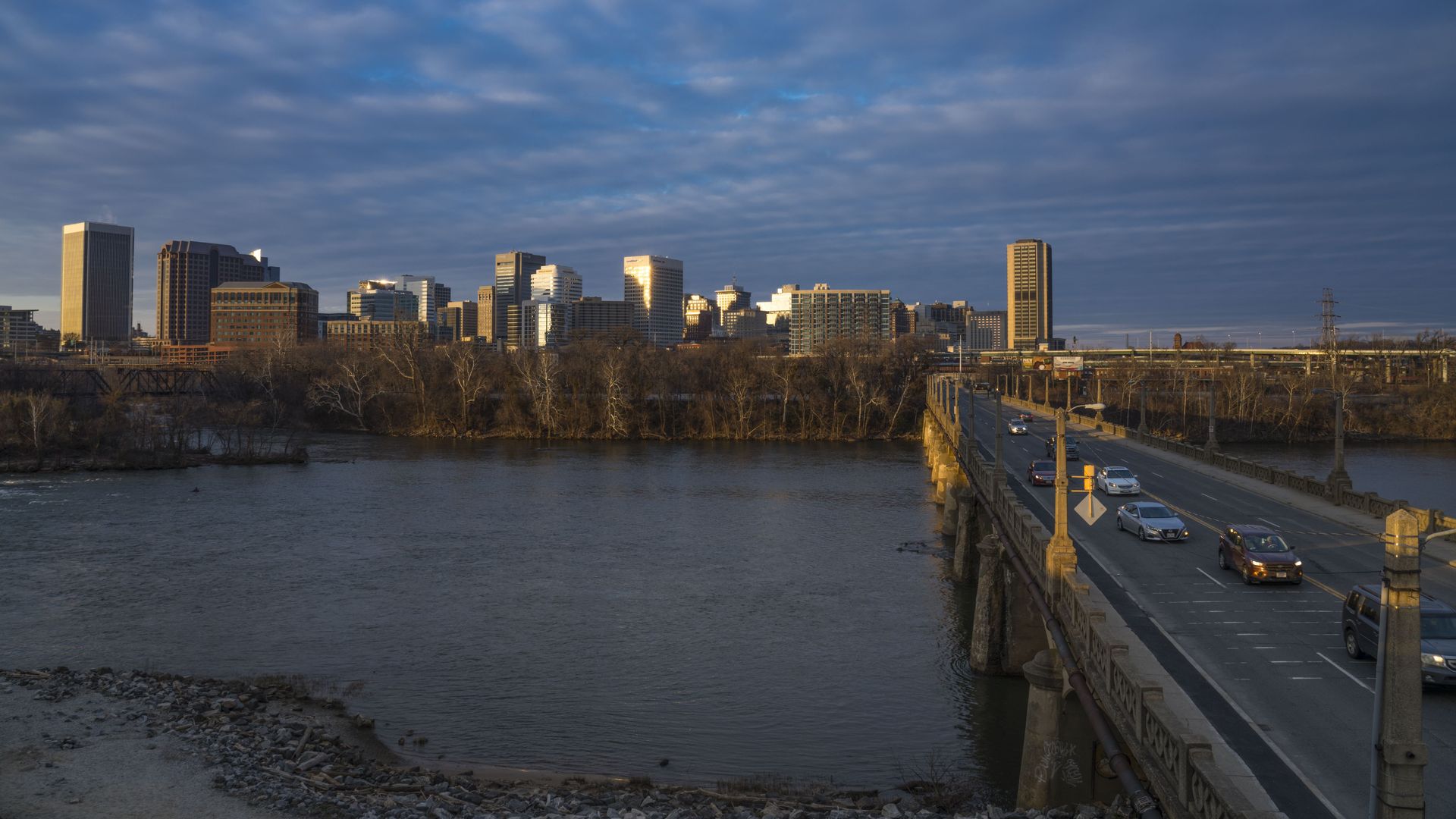 A picture of the James River, the Richmond skyline and a bridge with cars on it.