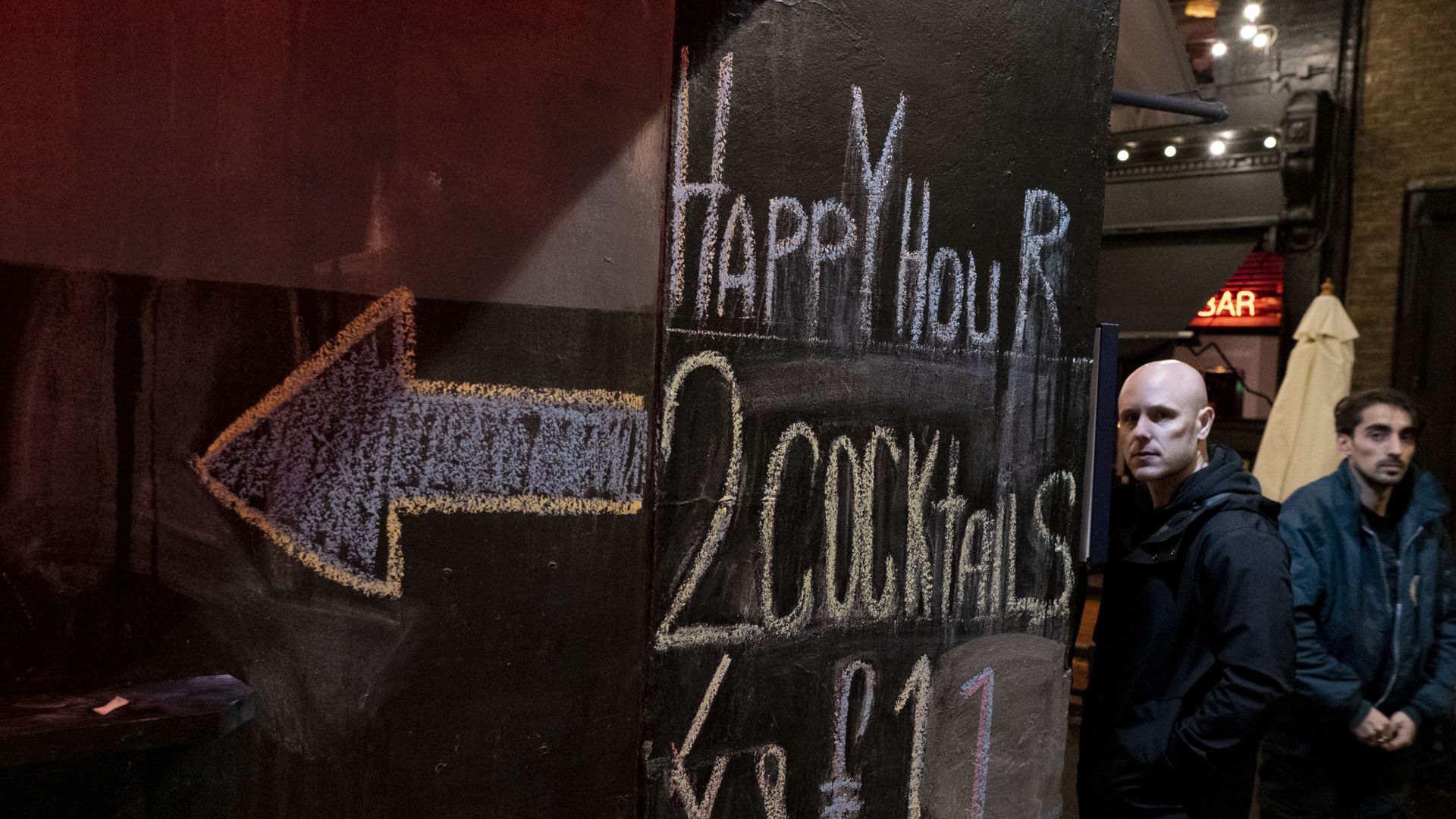 A sign advertising happy hour discounted drinks.