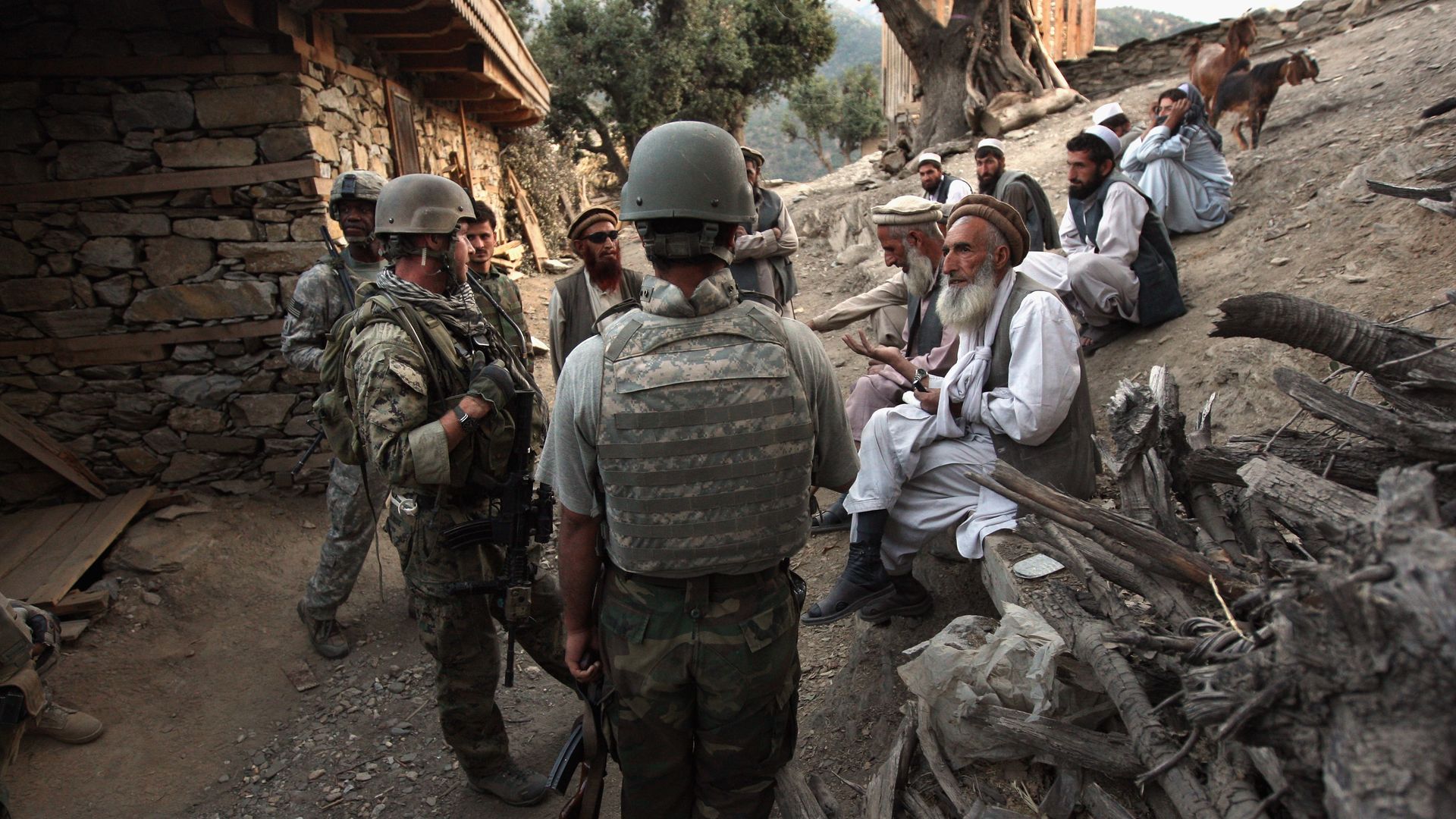Village elders speak with a U.S. Marine (L), through an interpreters in 2008.