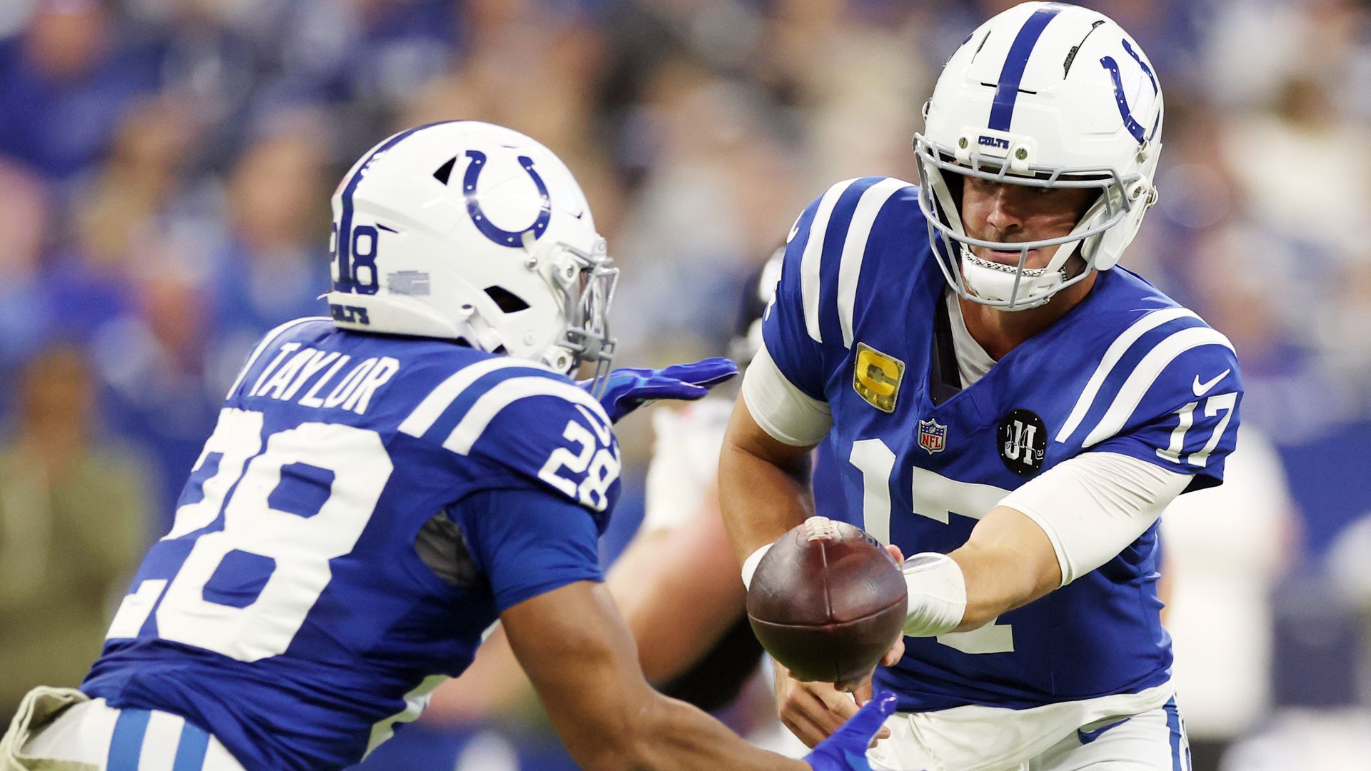 Daniel Jones #17 of the Indianapolis Colts hands the ball to Jonathan Taylor #28 against the Tennessee Titans during the first half in the game at Lucas Oil Stadium on October 26, 2025 in Indianapolis, Indiana.