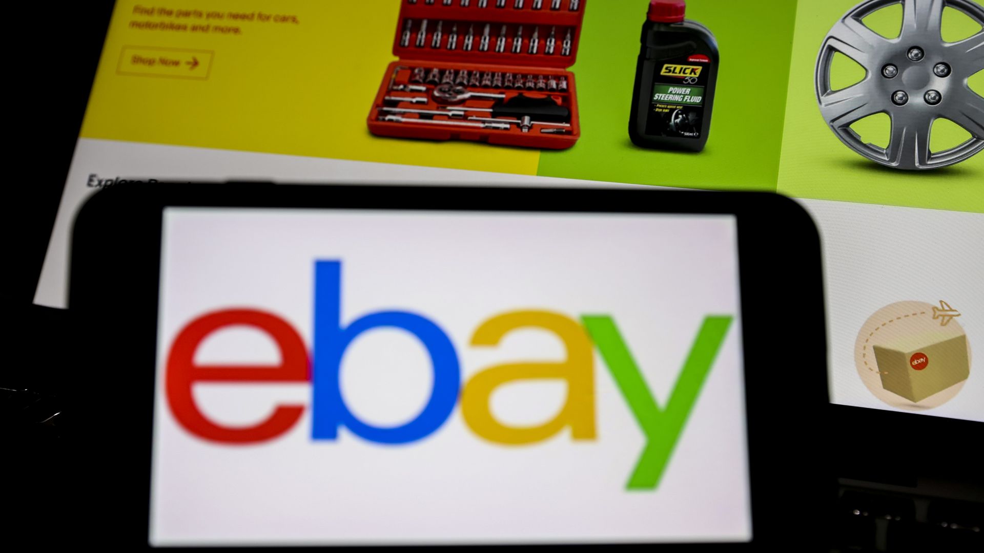 A photo illustration of the eBay logo on a phone, with an eBay Web page on a computer in the background