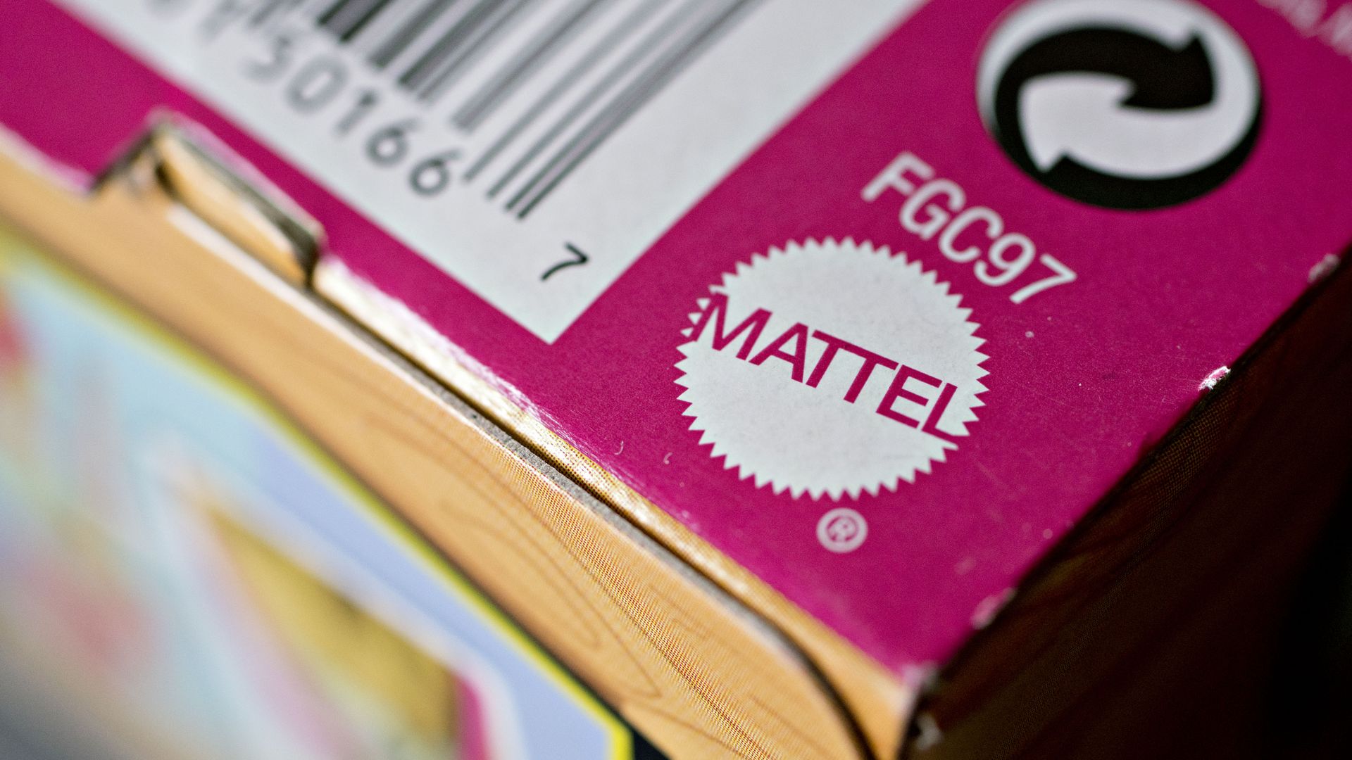 Close-up of a pink and yellow product box corner showing the Mattel logo, a barcode, and recycling symbol.