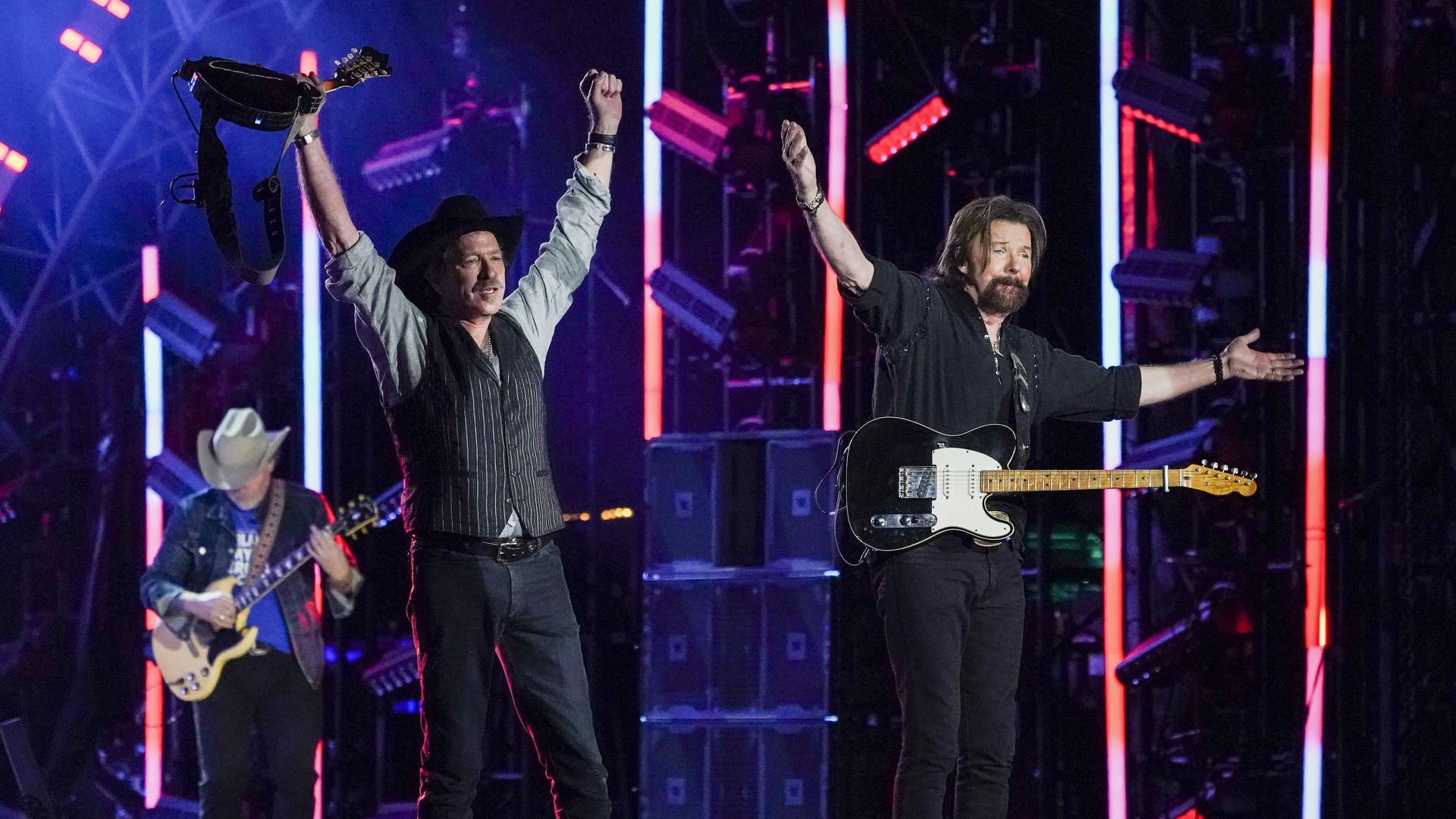 Brooks and Dunn celebrate after performing a song on stage
