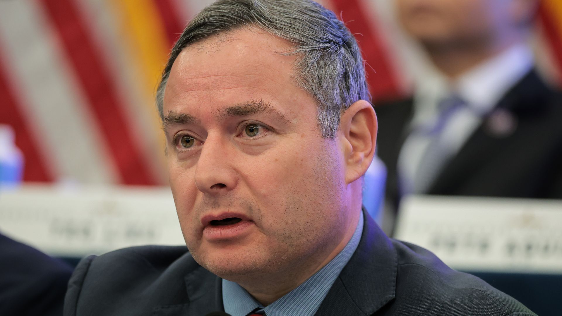 Vindman wearing a dark grey suit jacket, blue shirt and red and blue striped tie