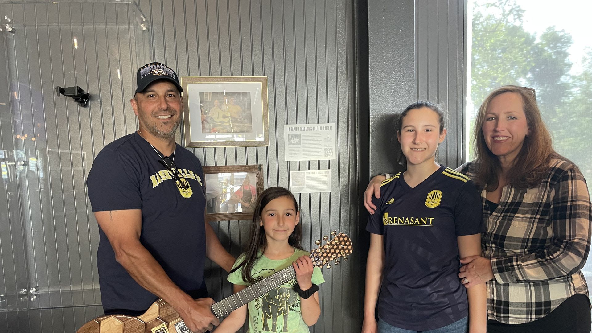 Luthier Manuel Delgado and his family pose with the guitar he custom built for Geodis Park.