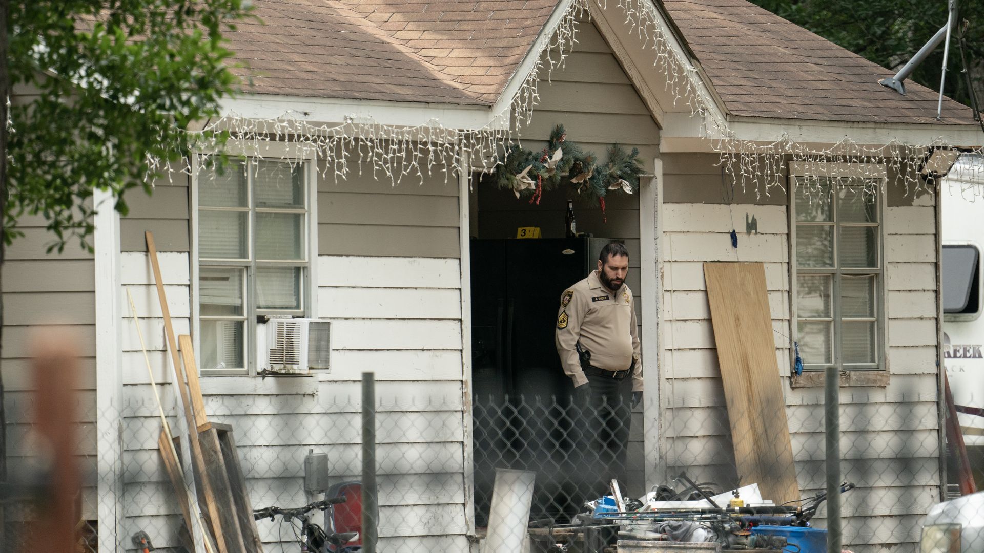 A sheriff's deputy exits a home in Cleveland, Texas where 5 people were killed. 