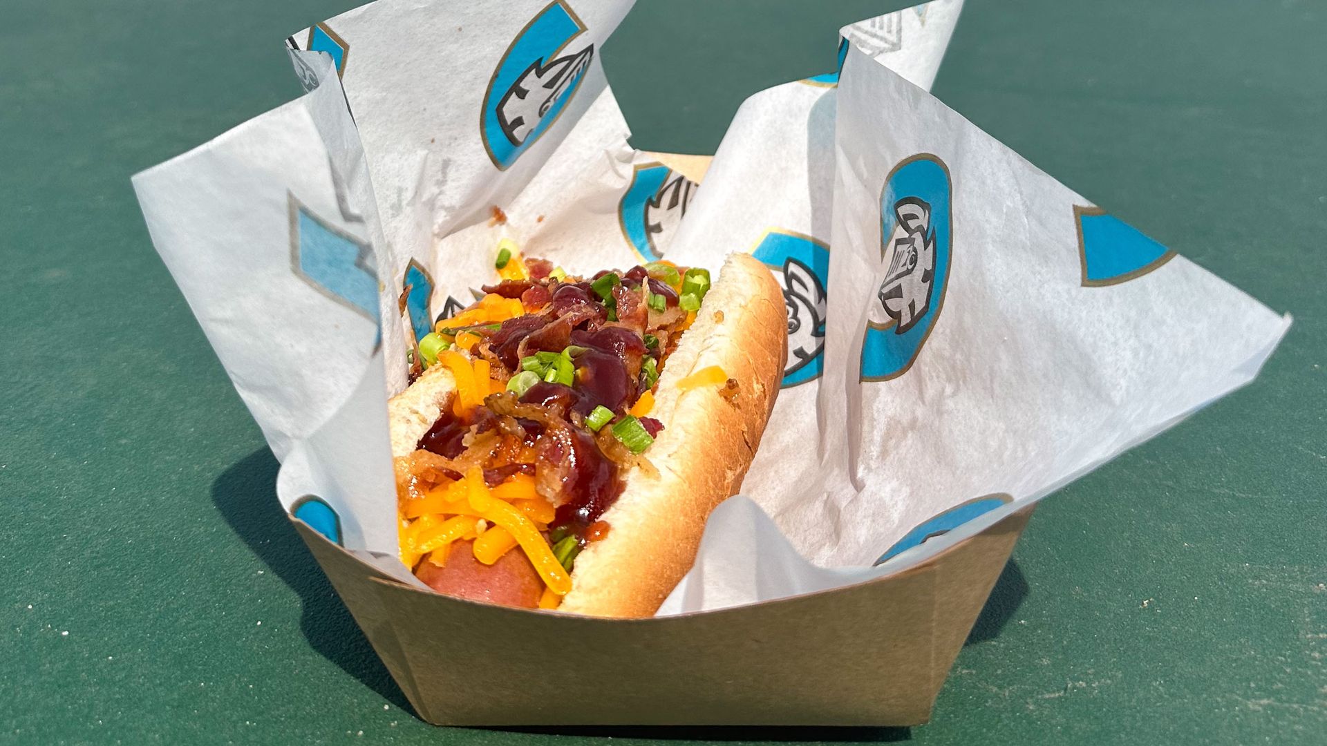 hot dog on a bun topped with cheese