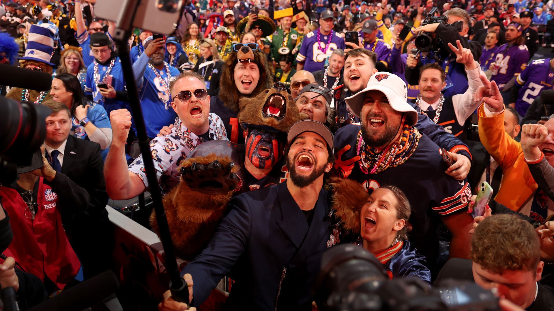 Photo of a man taking selfies with people around him 