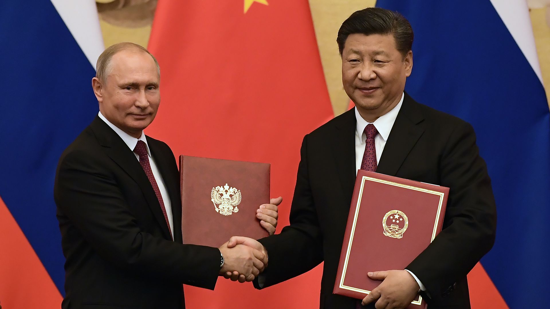  Chinese President Jinping congratulates Russian President Putin after presenting him with the Friendship Medal