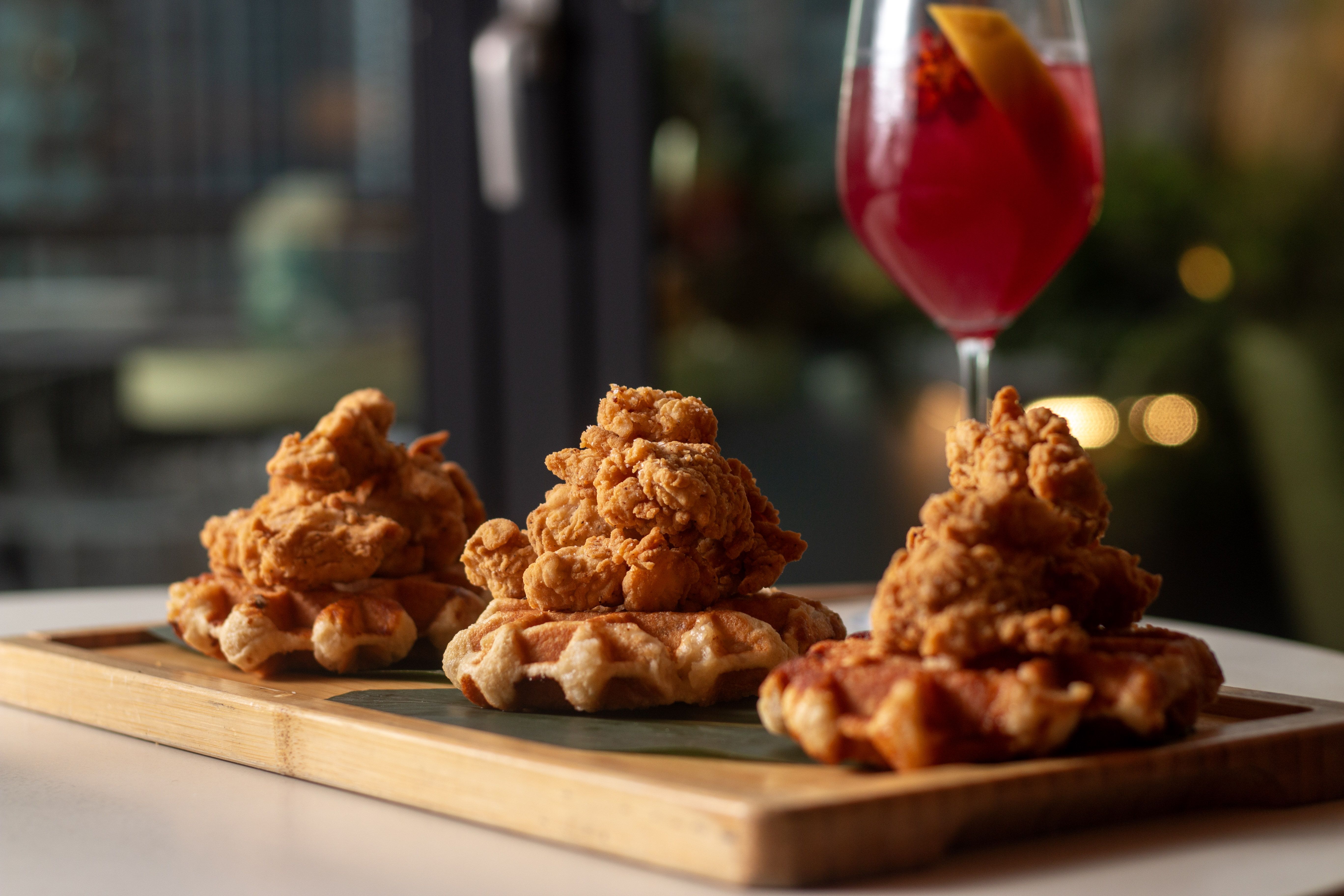 Fried chicken on top of three small waffles.