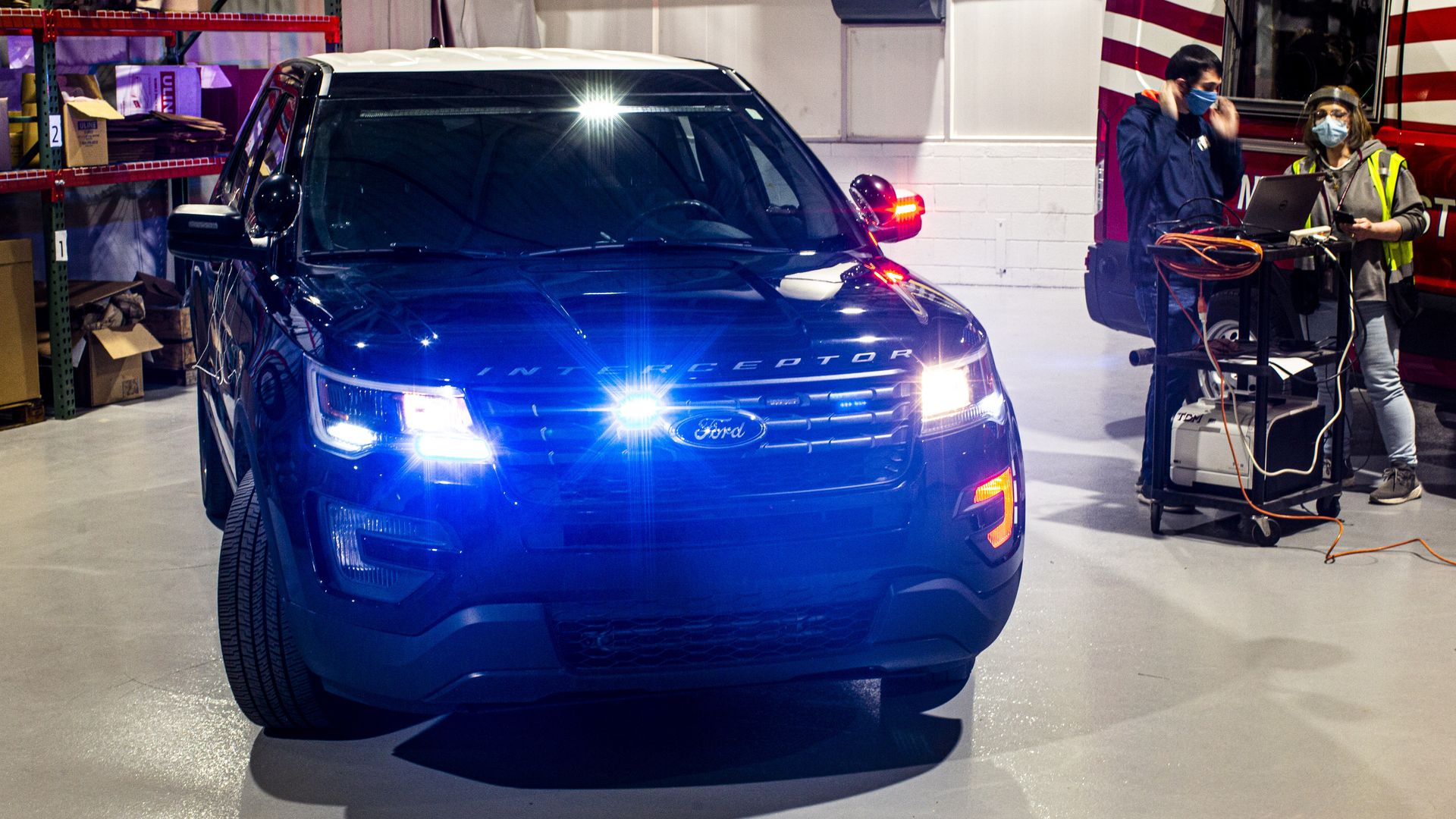 Image of Ford's self-cleaning police car with lights flashing to monitor progress.
