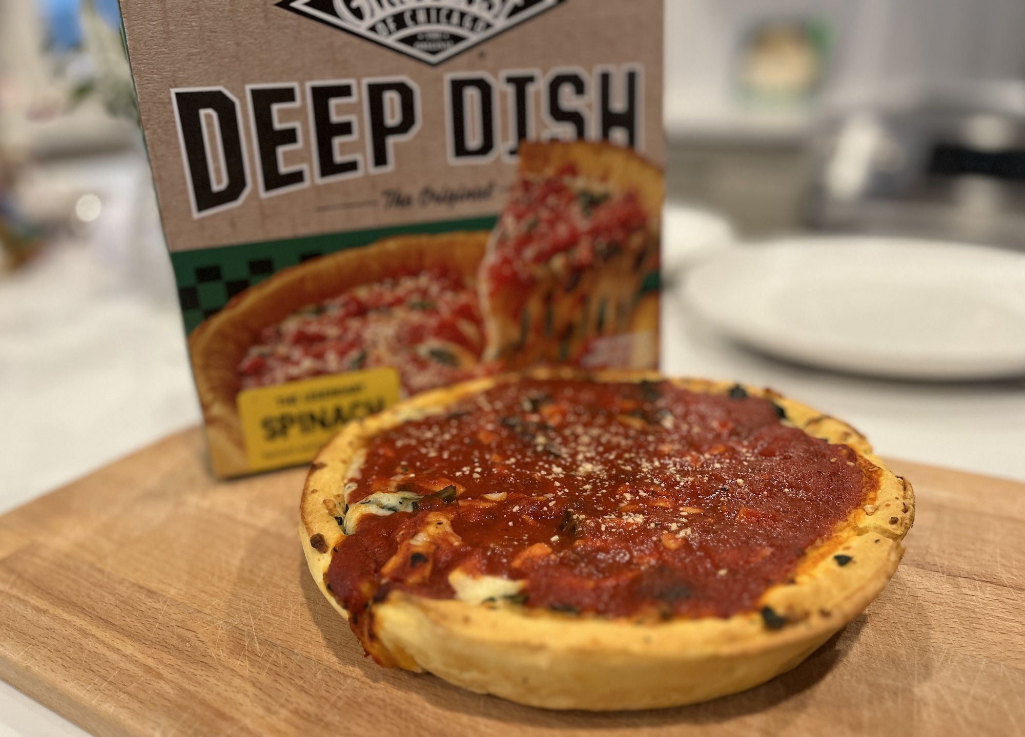 Small deep dish pizza in front of the Gino's East pizza box