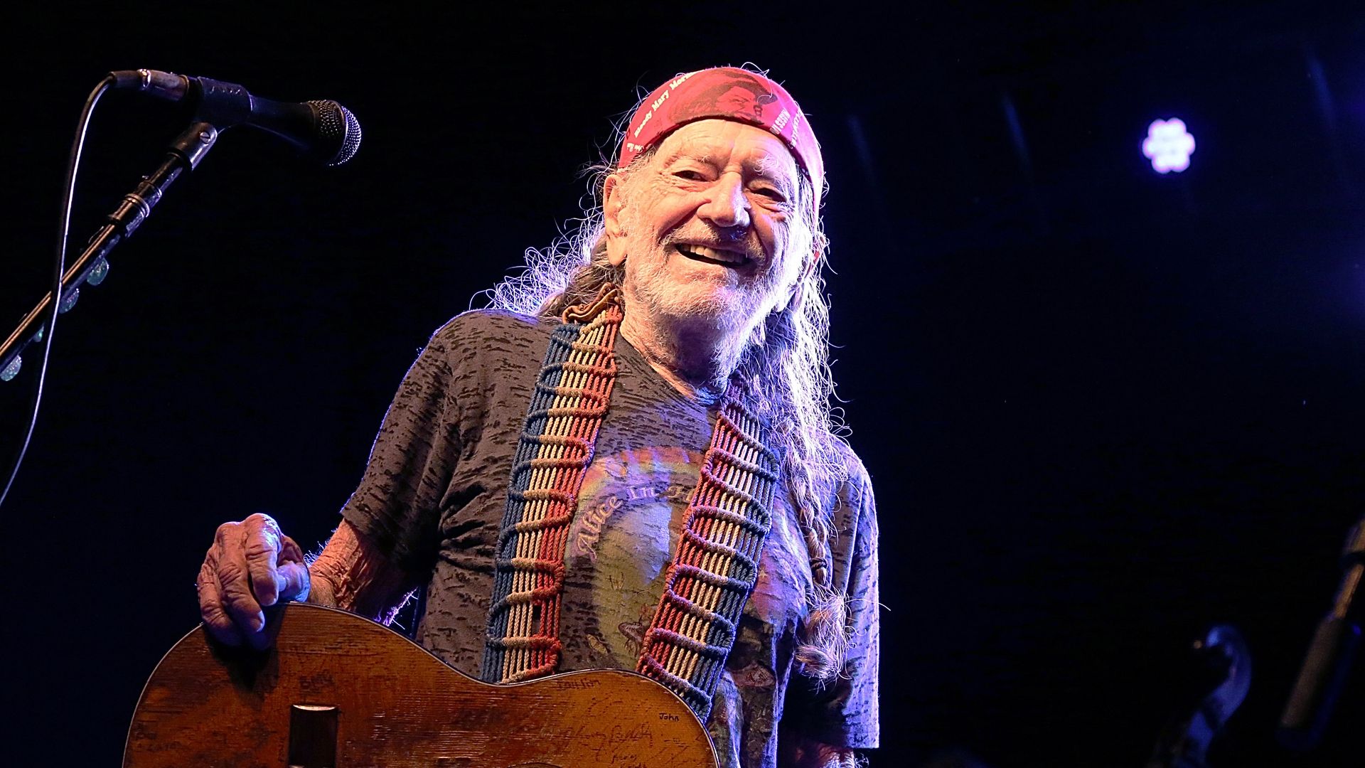 Willie Nelson smiles while on stage. 