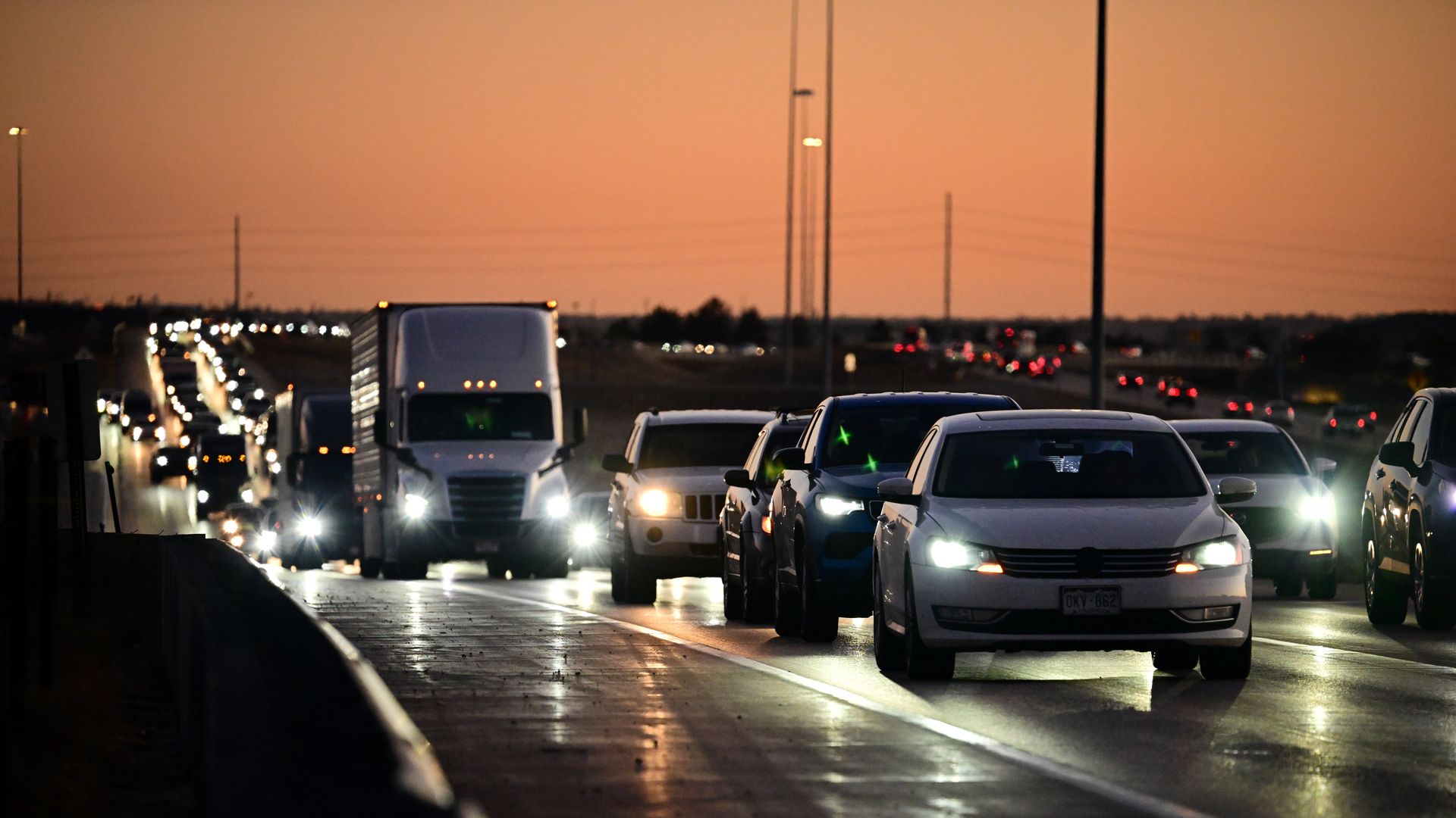 Several cars on a long roadway during an evening day. 